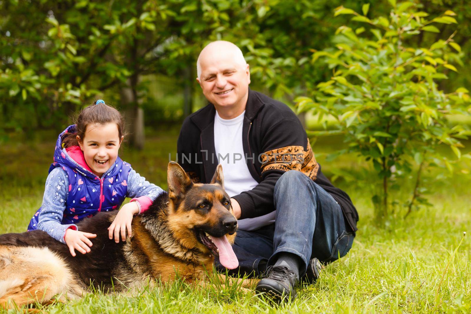 Grandfather And Granddaughter Taking Dog For Walk