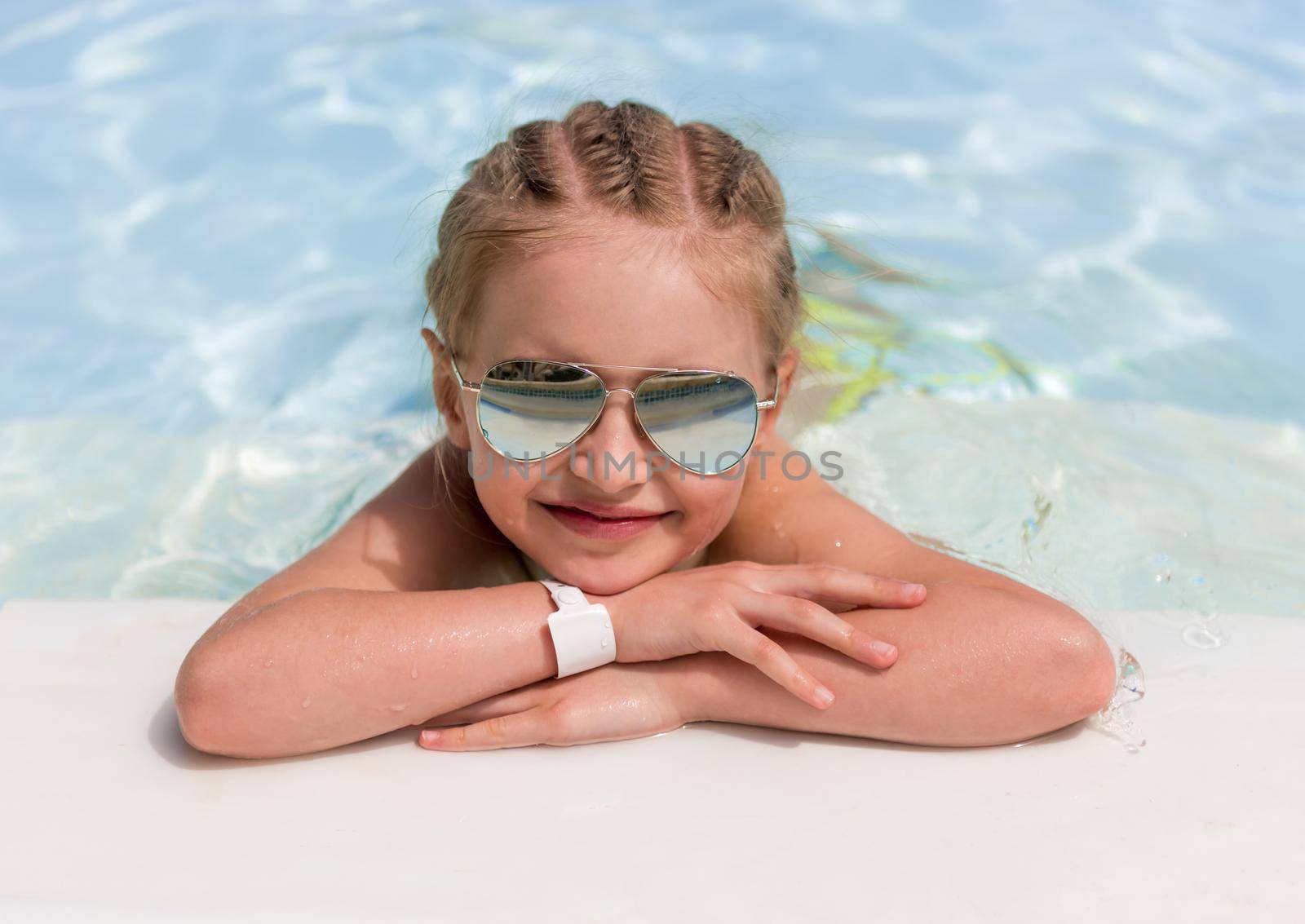 Relaxed girl kid laying on clear white poolside