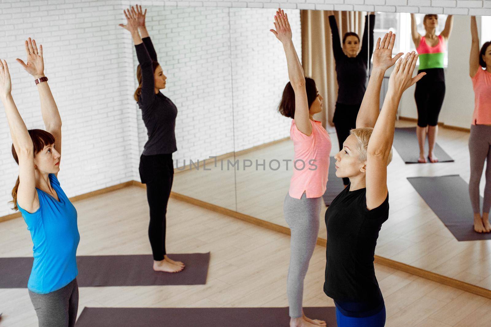 A group of women doing yoga by Demkat