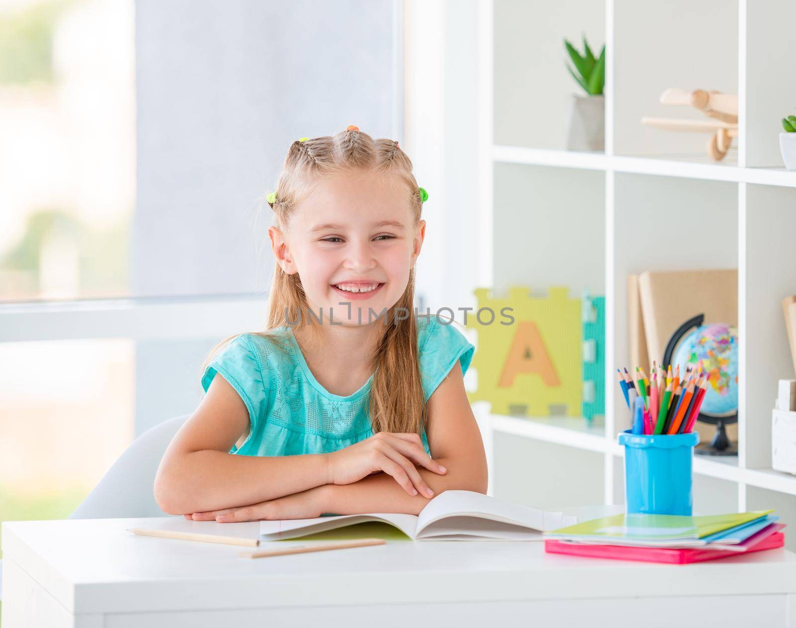 Elementary school girl doing task with pencil indoors