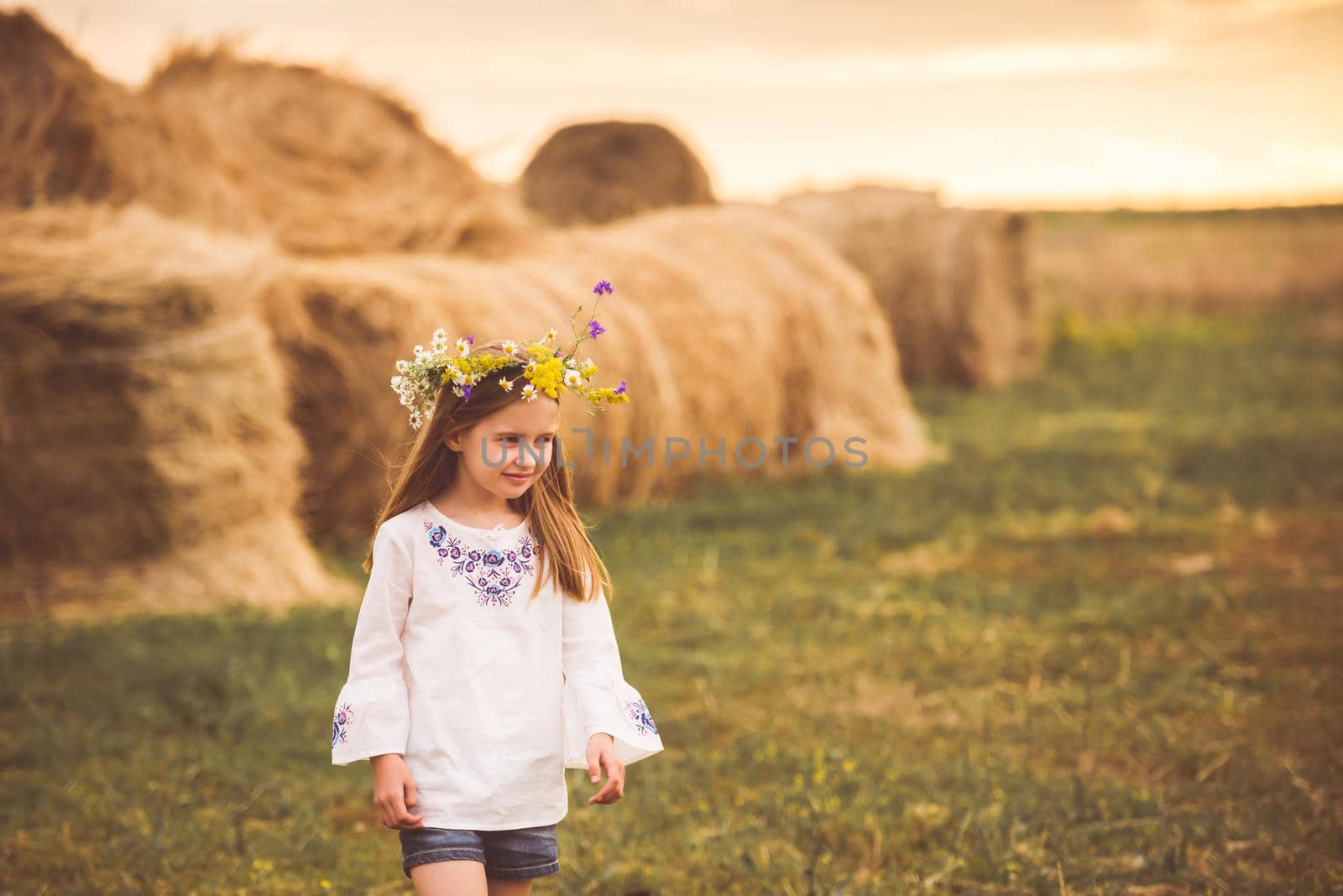 Young pretty kid girl walking around and seeing summer rural beauty