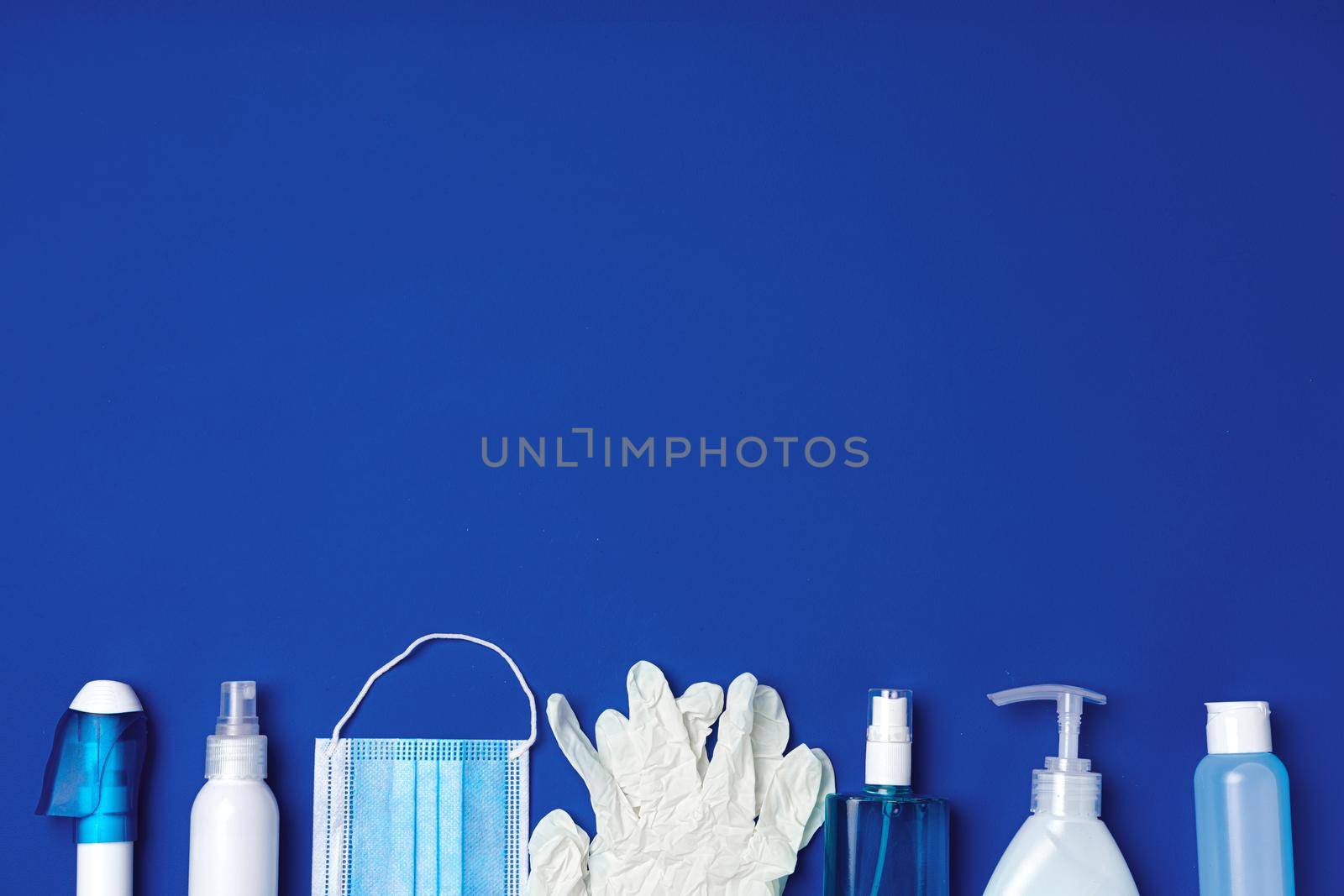 Row of antibacterial protective tools including face mask, gloves, soap and sanitizing gel. Top view, copy space