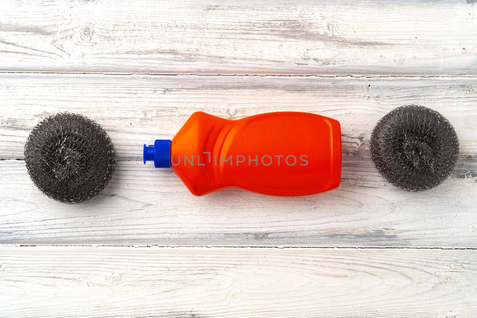 Home cleaning supplies on white wooden background, top view photo