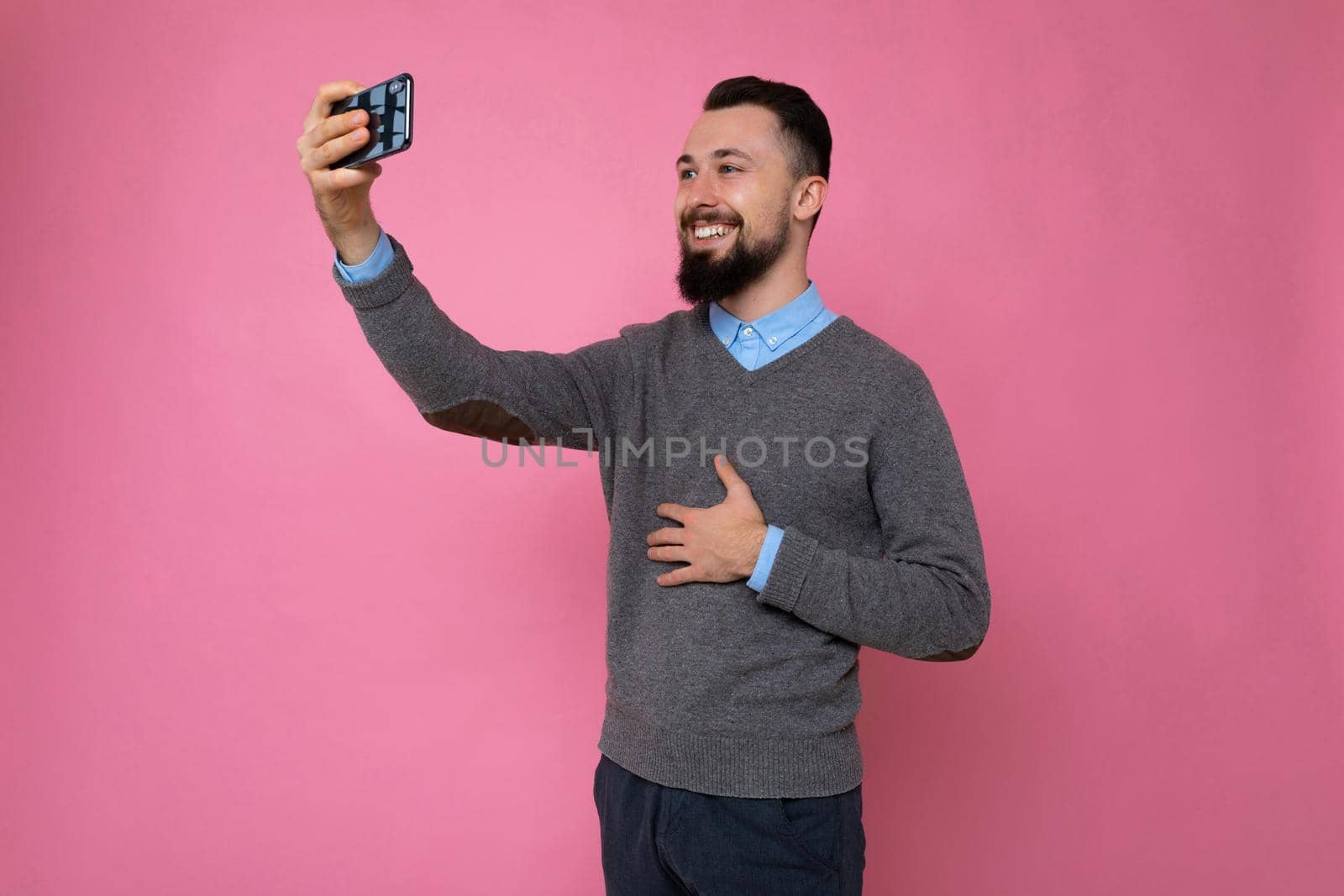young guy on a pink background takes a selfie by TRMK