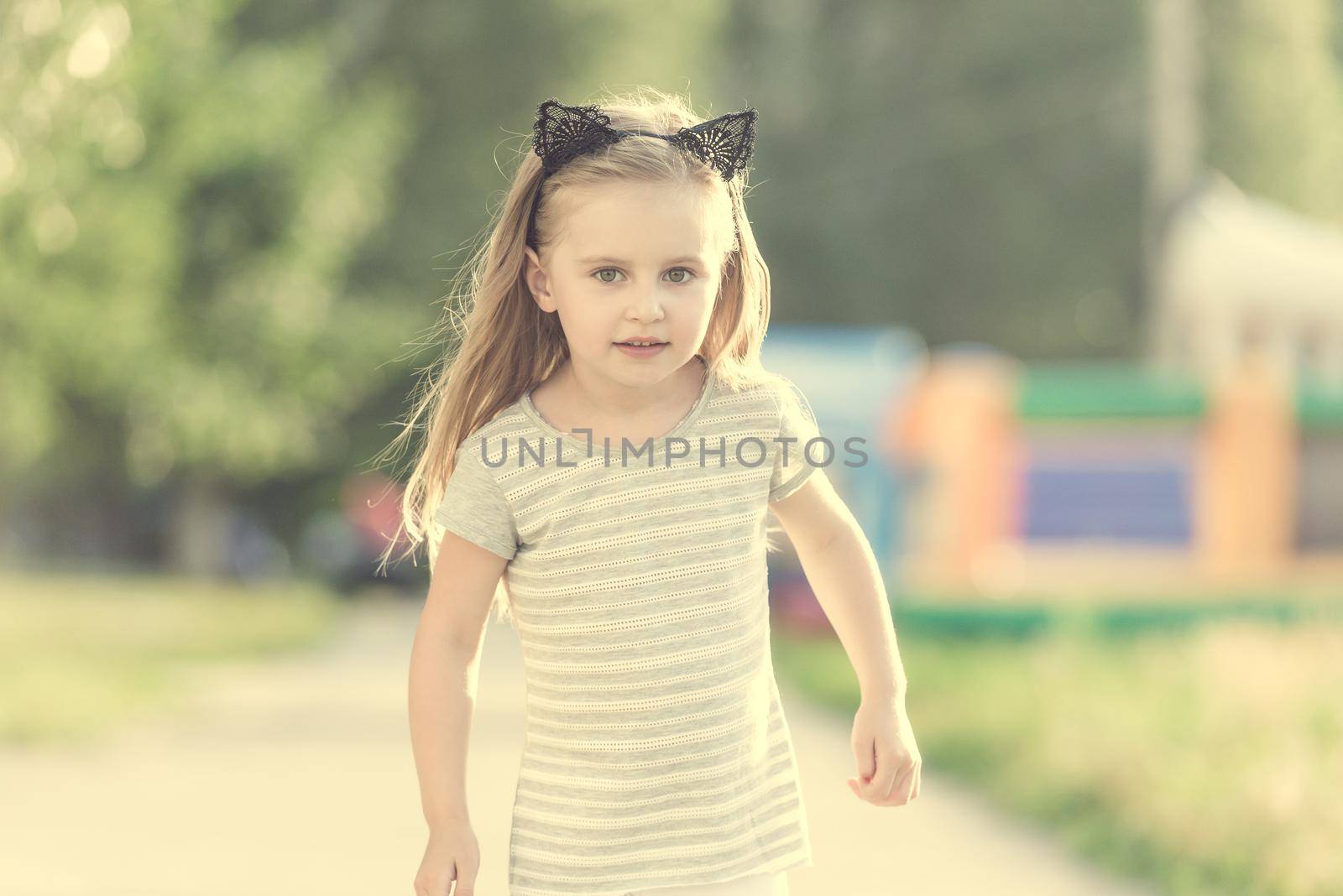 Little happy girl walking on the street