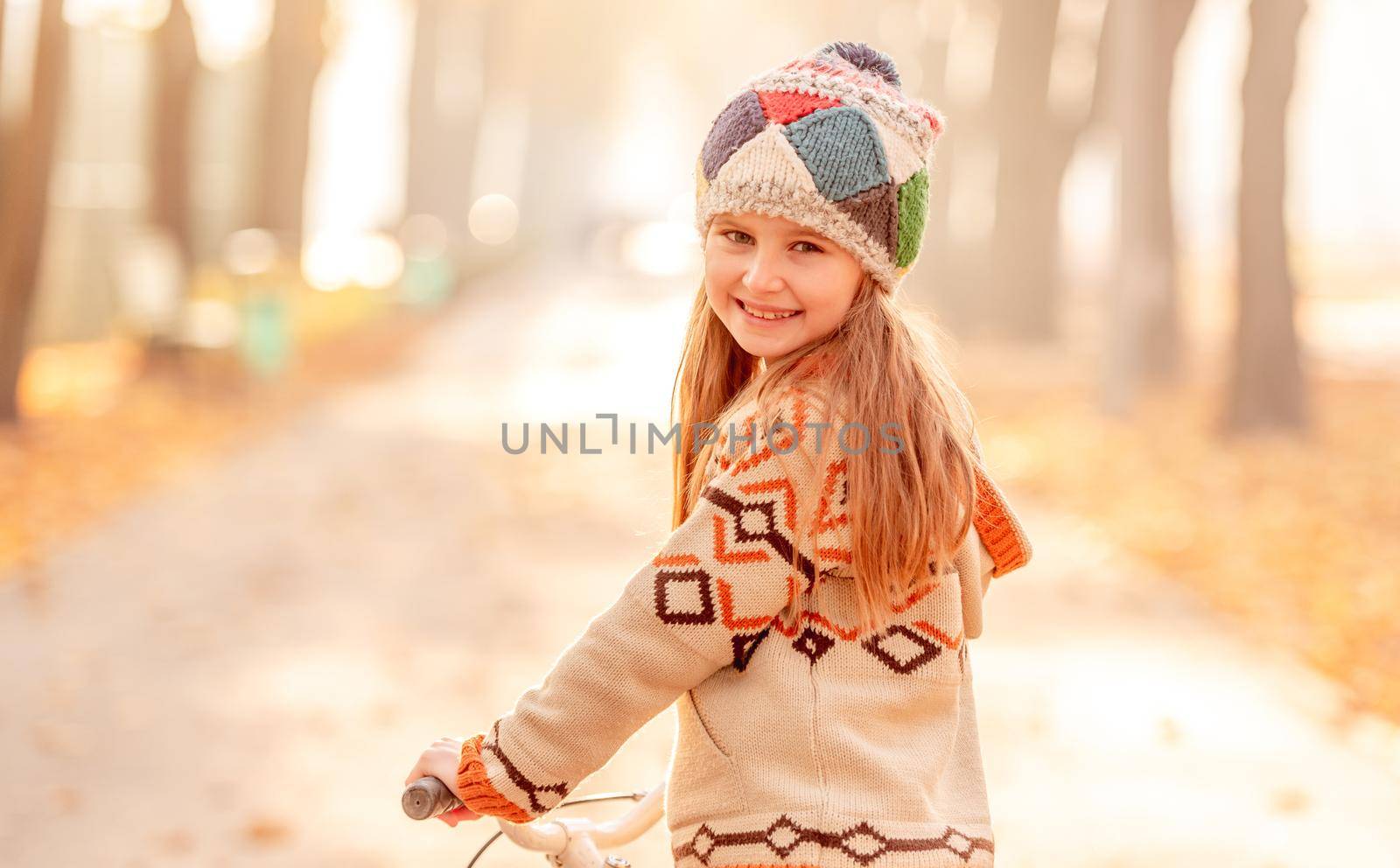 Cute child with bicycle in autumn surroundings