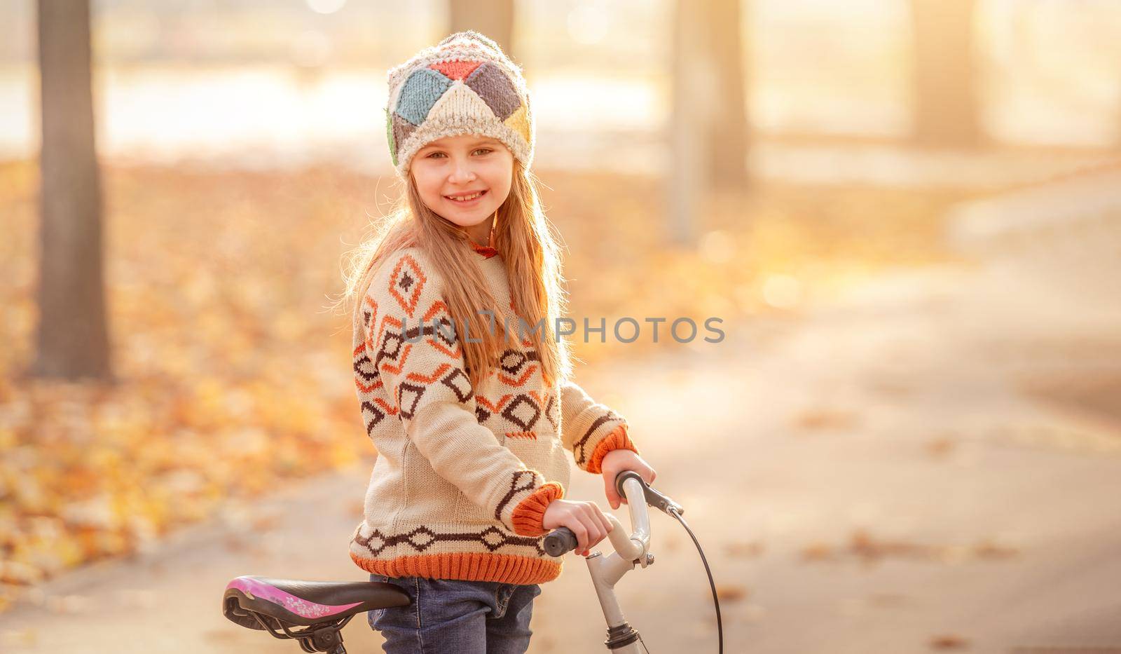 Cute child with bicycle in autumn surroundings
