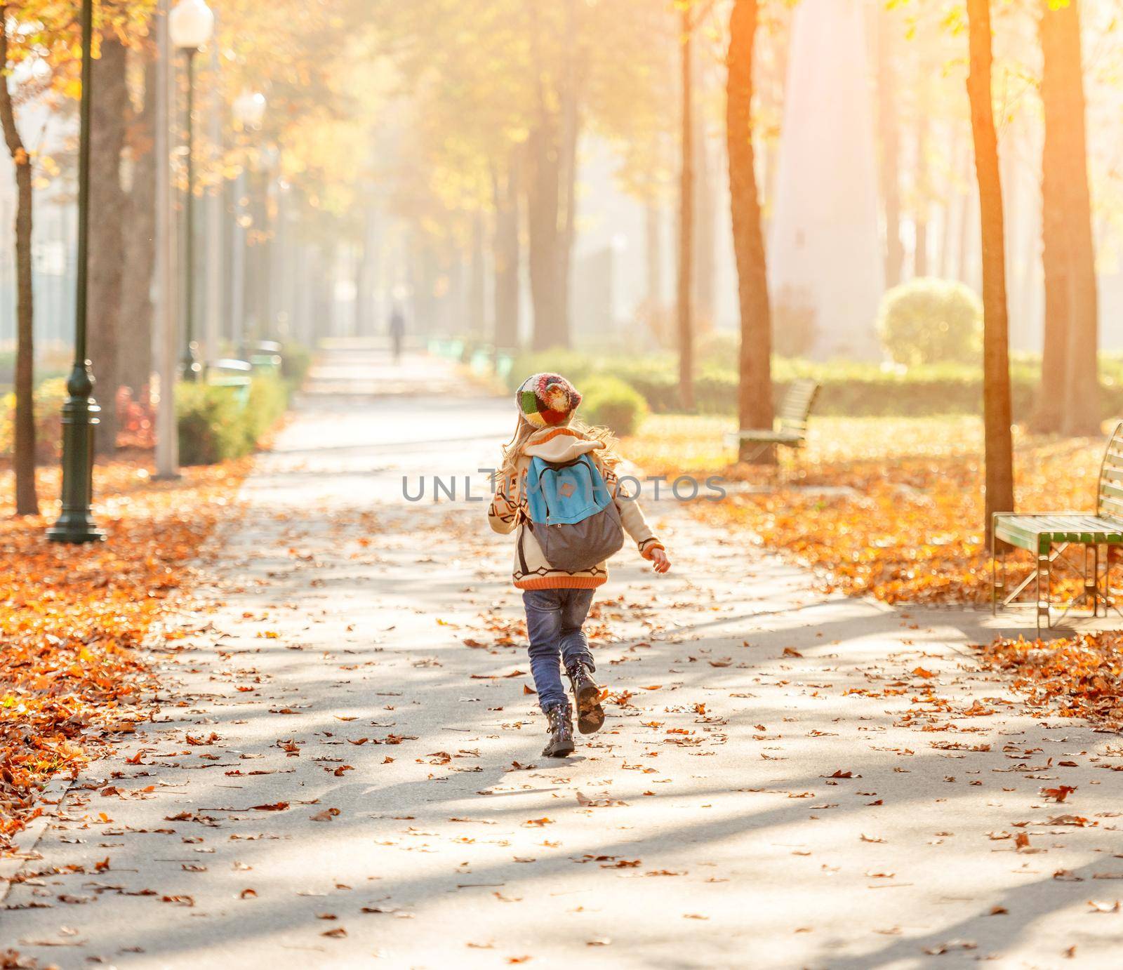Happy kid after school running in park