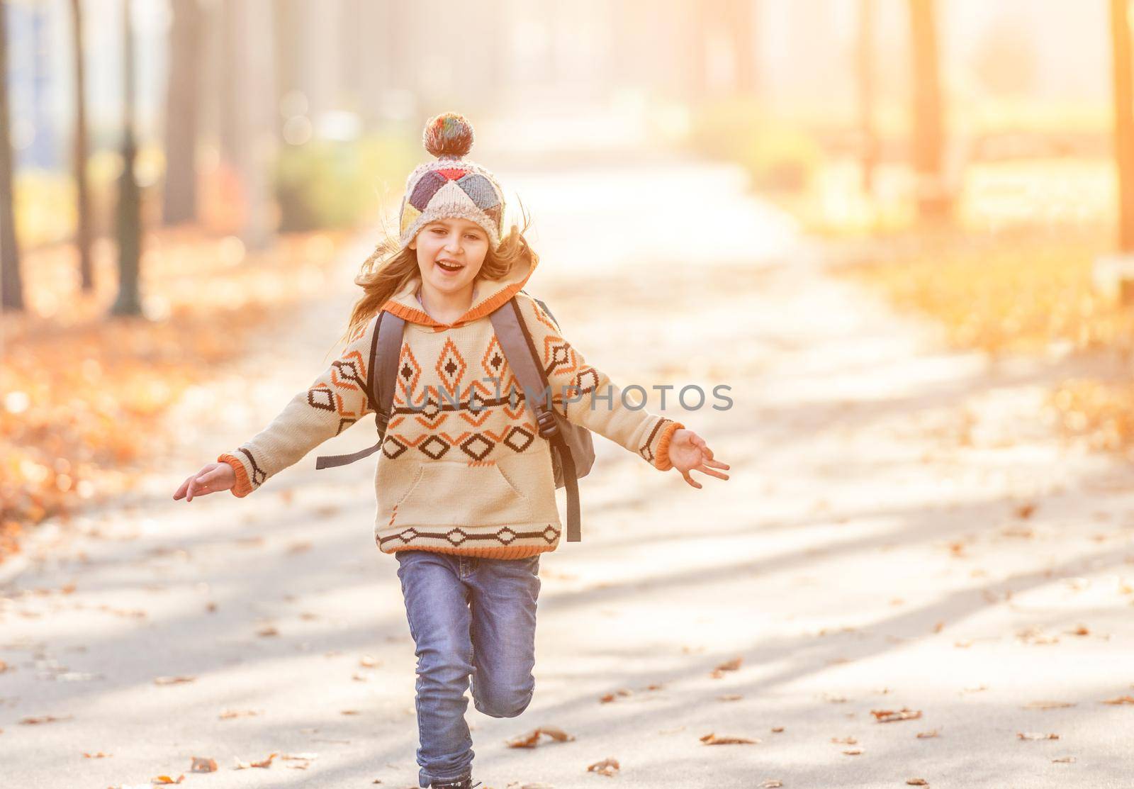Smiling schoolchild after lessons in autumn park