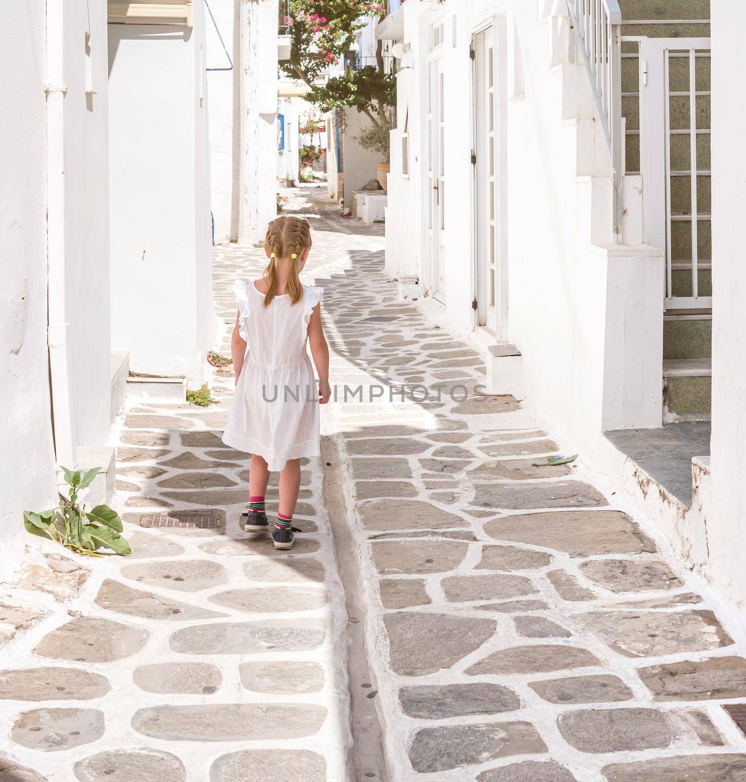 Little girl walking the narrow alley in Greece by tan4ikk1