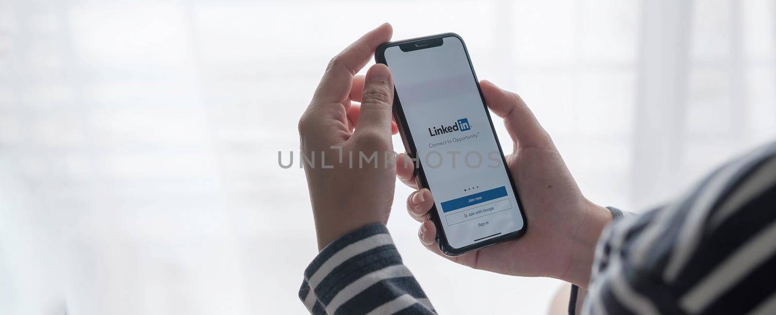 CHIANG MAI, THAILAND, JUL 12, 2021 : A women holds Apple iPhone Xs with LinkedIn application on the screen.LinkedIn is a photo-sharing app for smartphones..