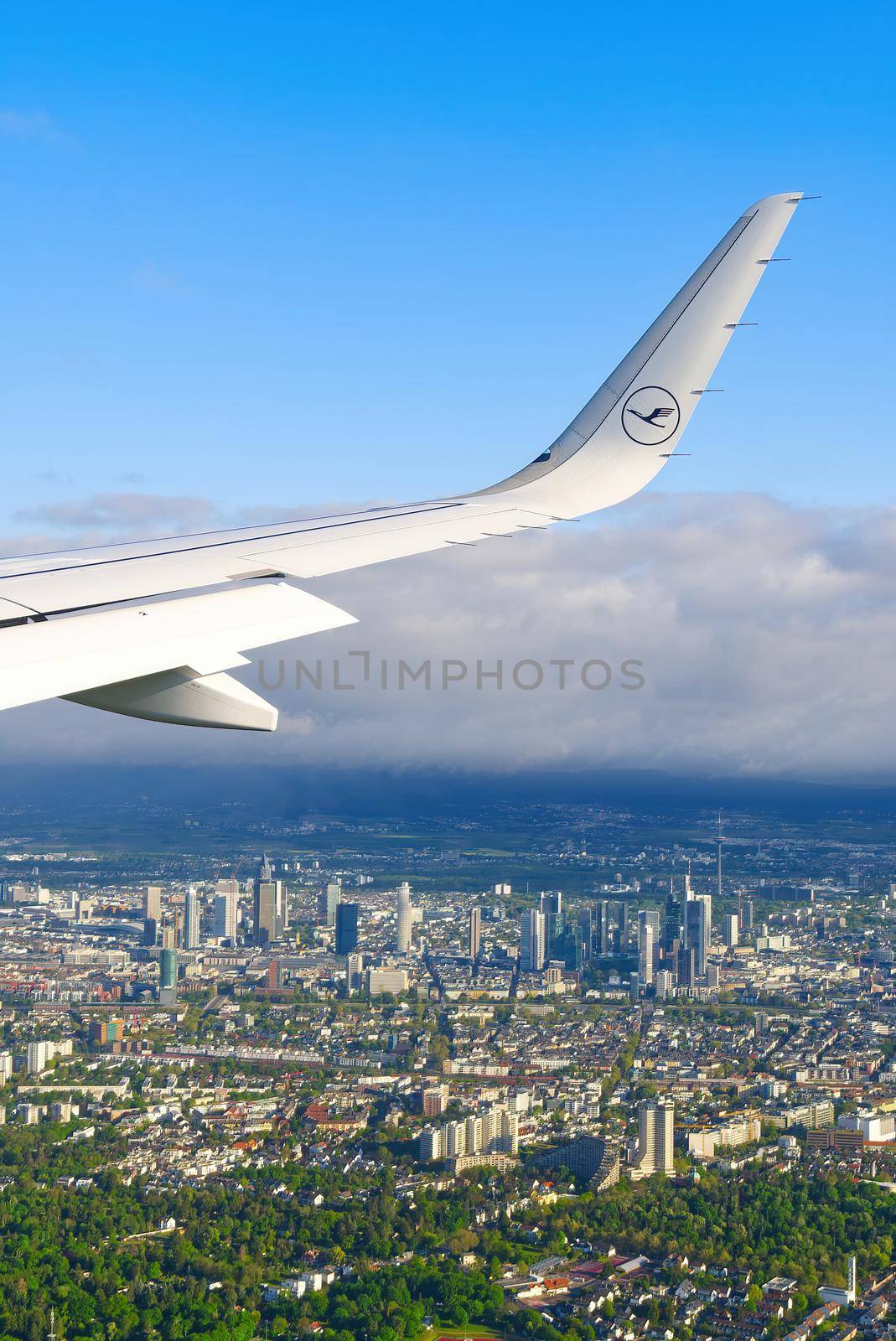 22.05.2021 Frankfurt, Germany - The Airbus A321 wing with Lufthansa airline logo and blue sky over clouds background. airplane wing on landing in frankfurt am main