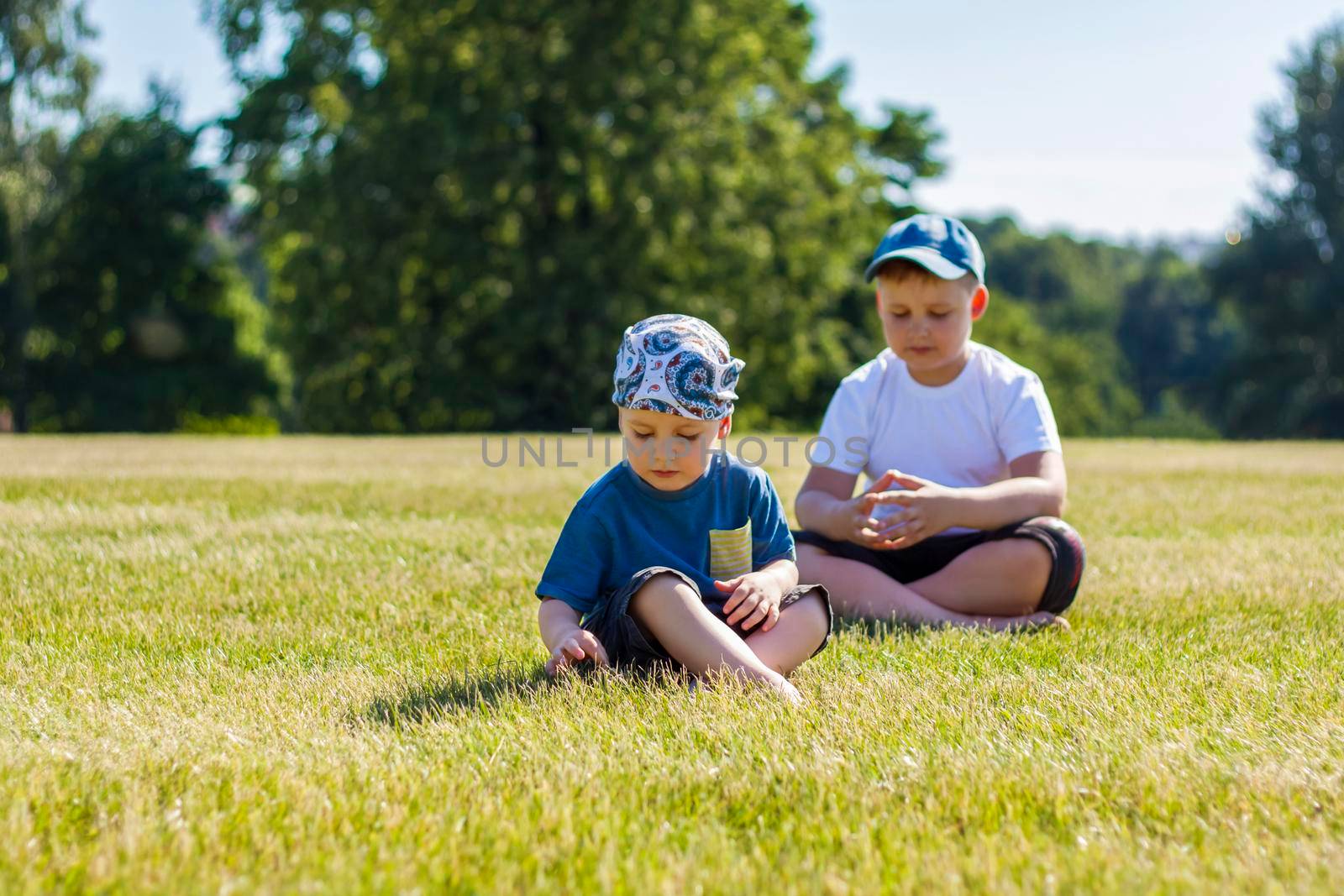 Cheerful children, two brothers, smile with joy. we are happy to walk and play on the lawn in warm sunny weather in the park. the emotions of children on the face. Happiness 