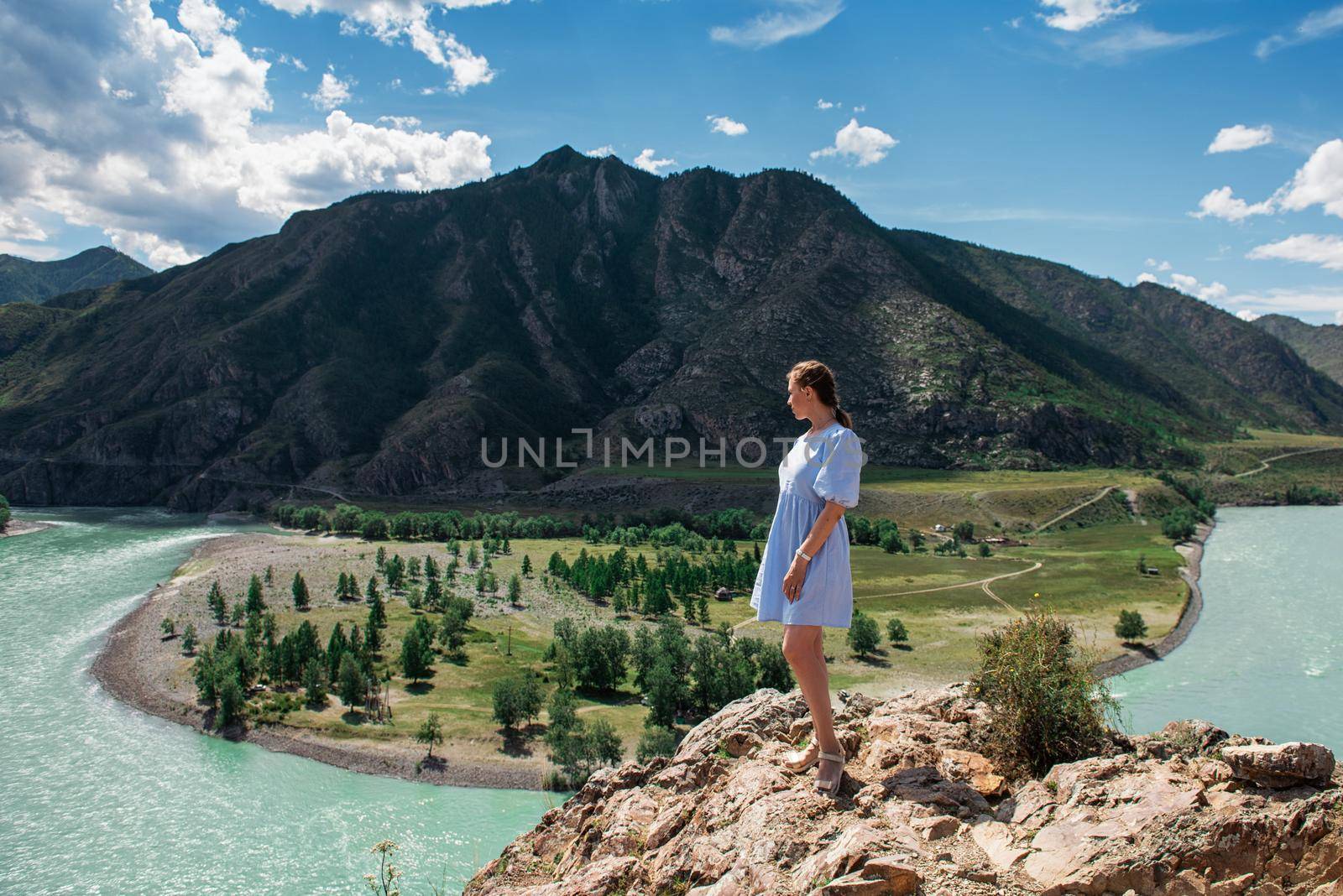 Woman in blue dress on the confluence of two rivers Katun and Chuya in Altai mountains, beauty summer day