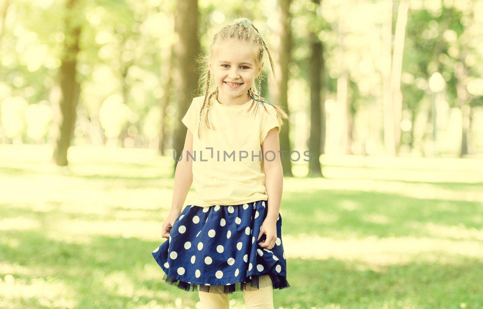 cute little girl have a fun in the morning park. blurred background