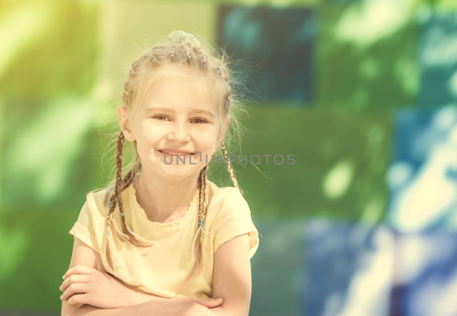 cute little girl smiling in the morning park. blurred background