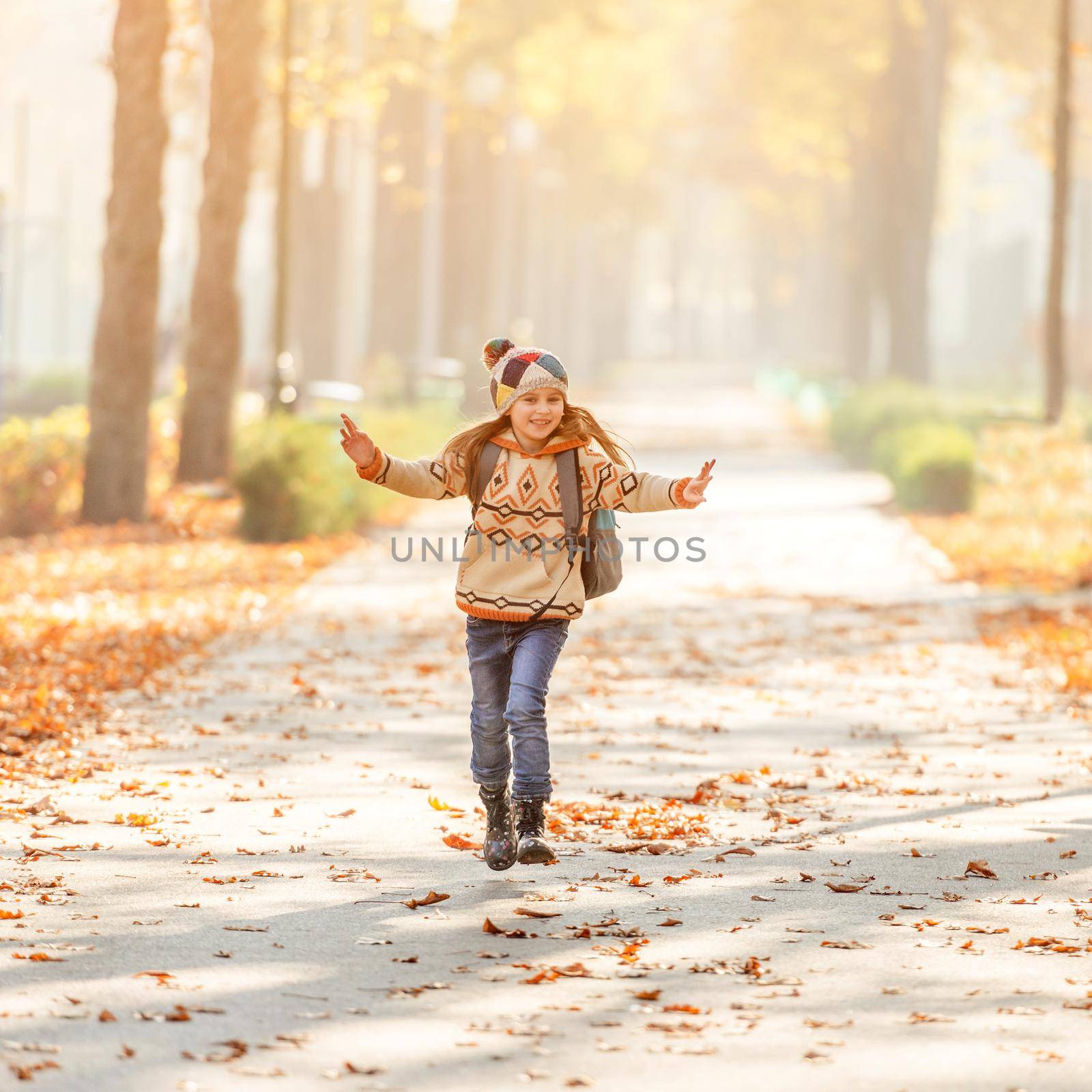 Smiling schoolchild after lessons in autumn park