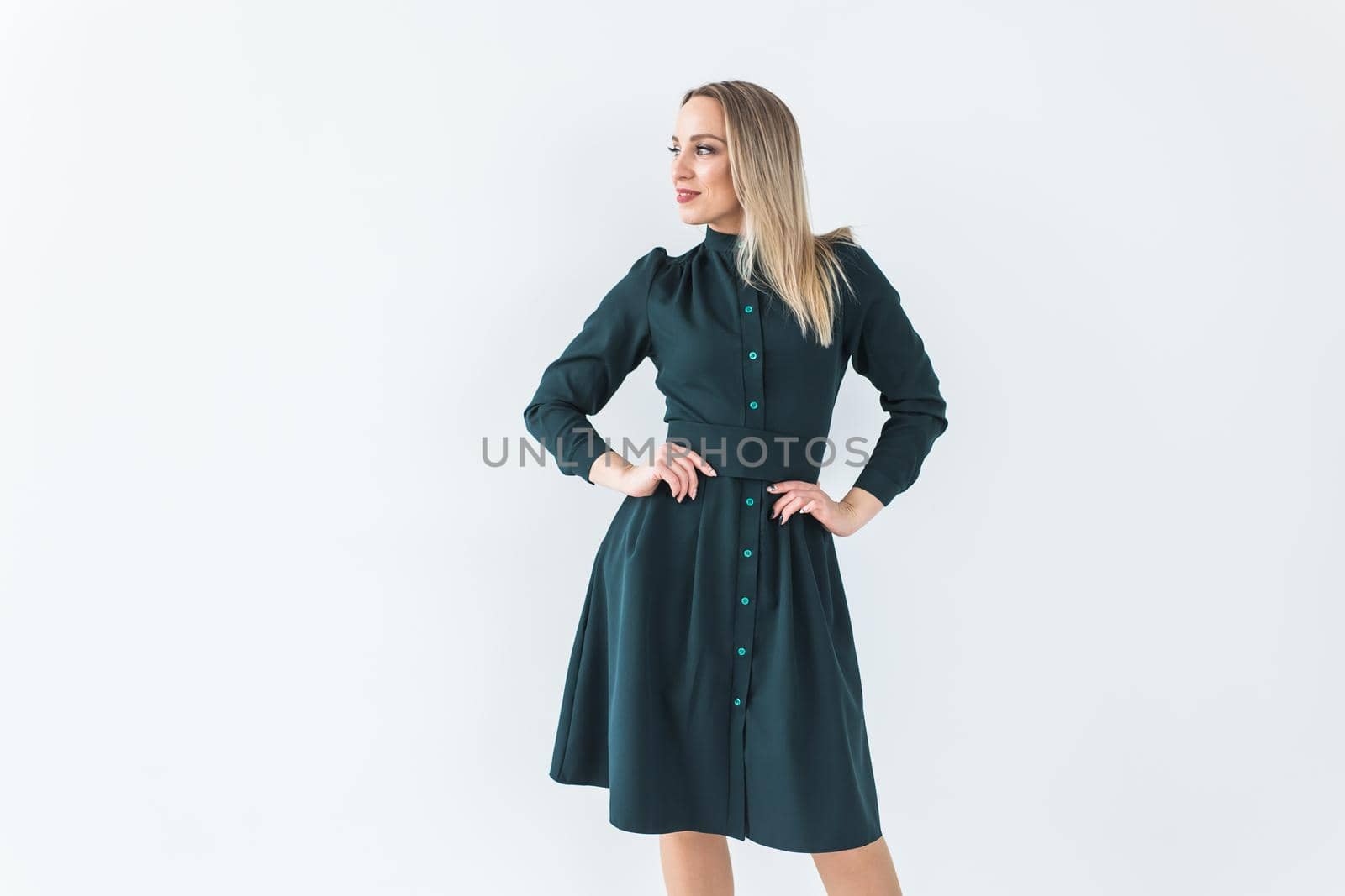 Fashionable young woman in beautiful dress posing at studio. Isolated over white.