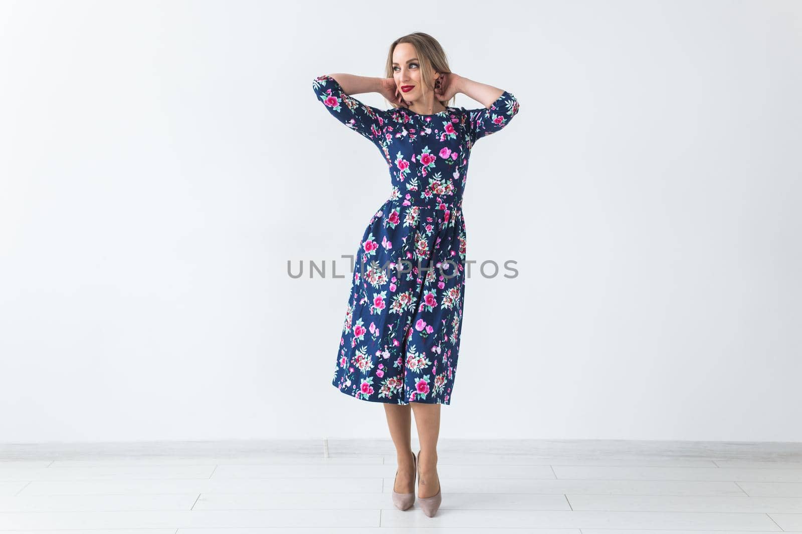 Fashionable young woman in beautiful dress posing at studio. Isolated over white.
