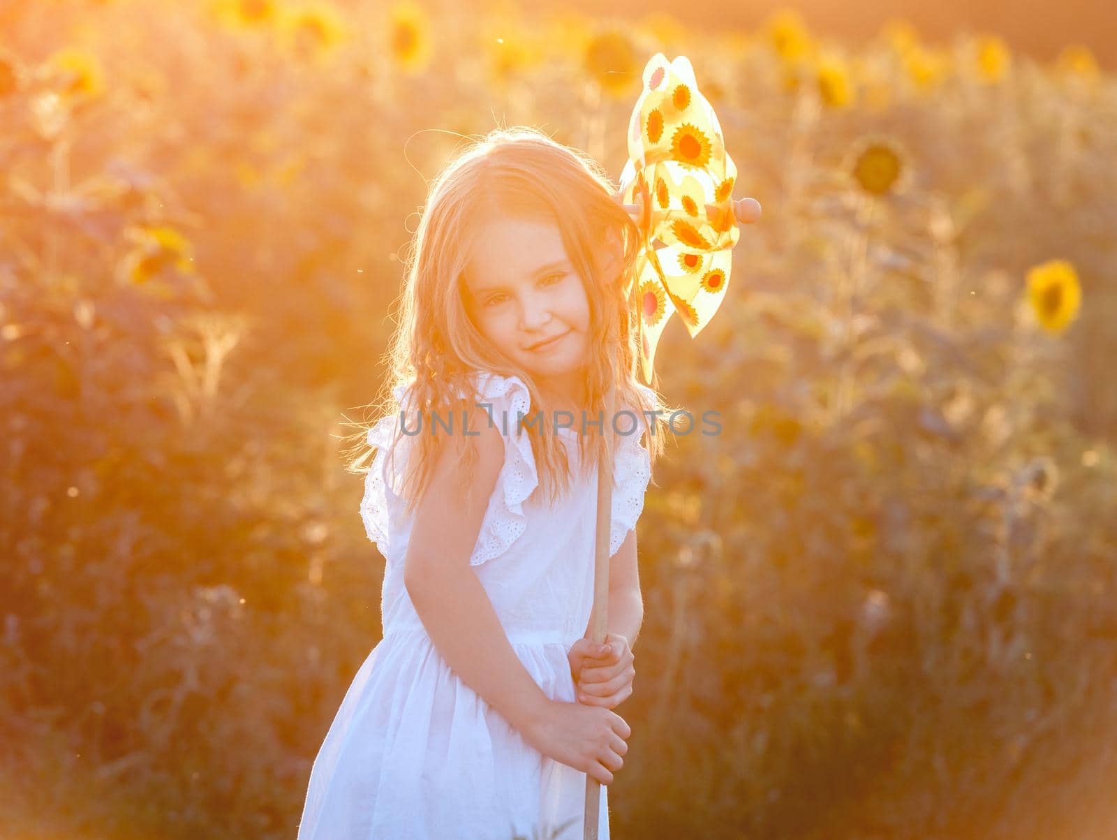 cute little girl in summer day holds windmill in hand