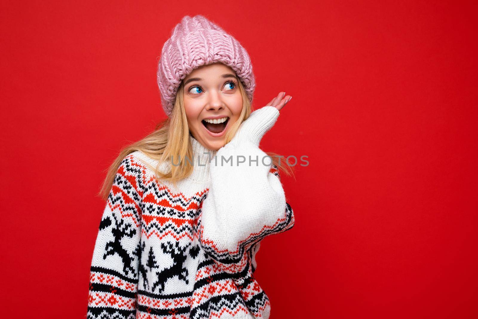 Beautiful positive happy young blonde woman isolated over colourful background wall wearing casual stylish clothes feeling sincere emotions looking to the side. Copy space