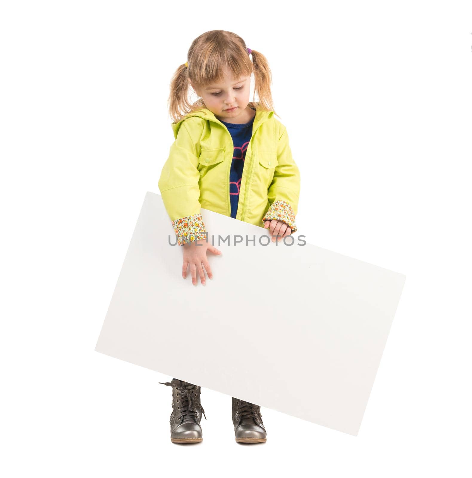 cute little girl in yellow coat with blank sheet in hands isolated on white background