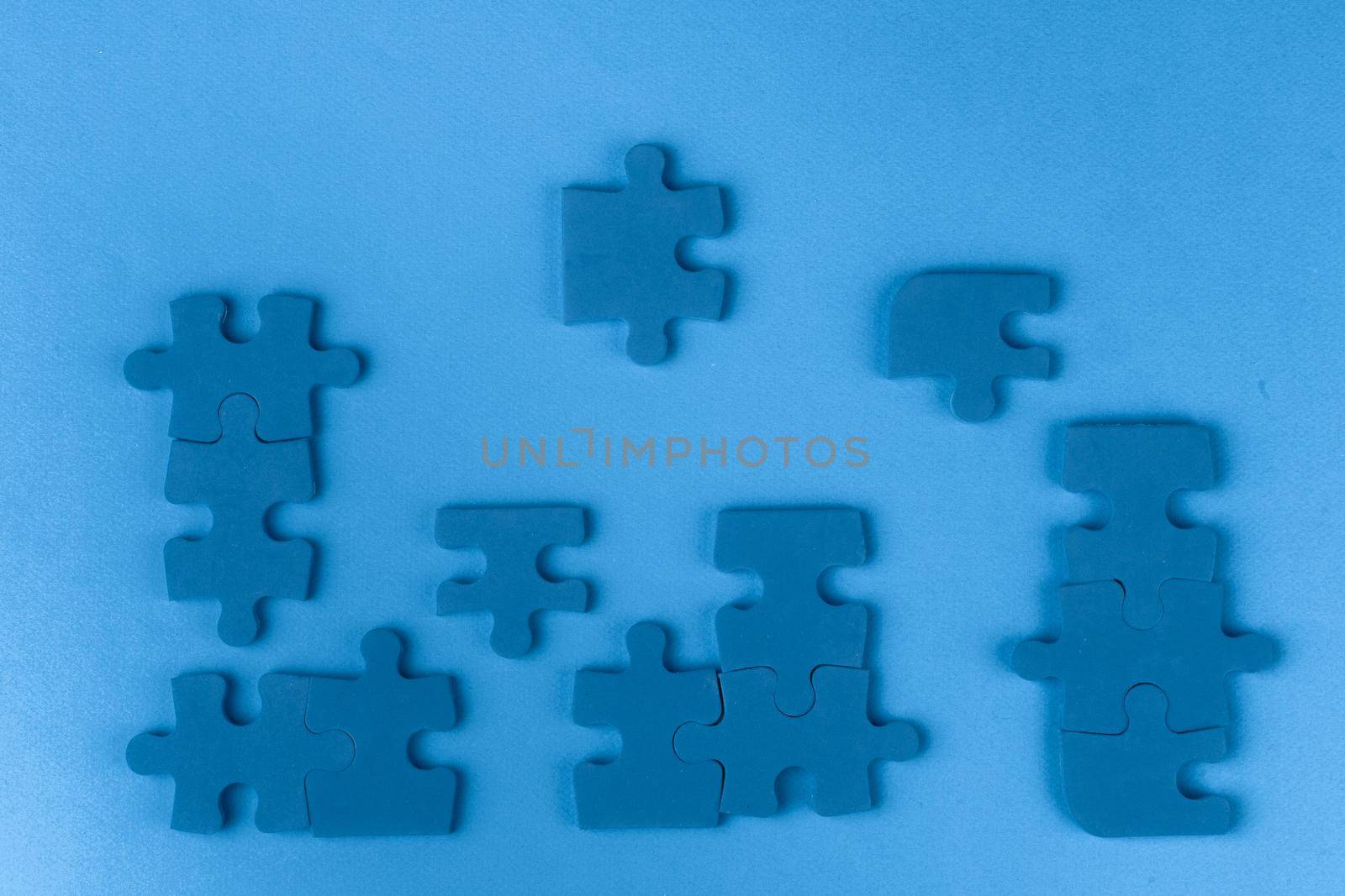 Puzzle pieces on classic blue background, top view. Close up.