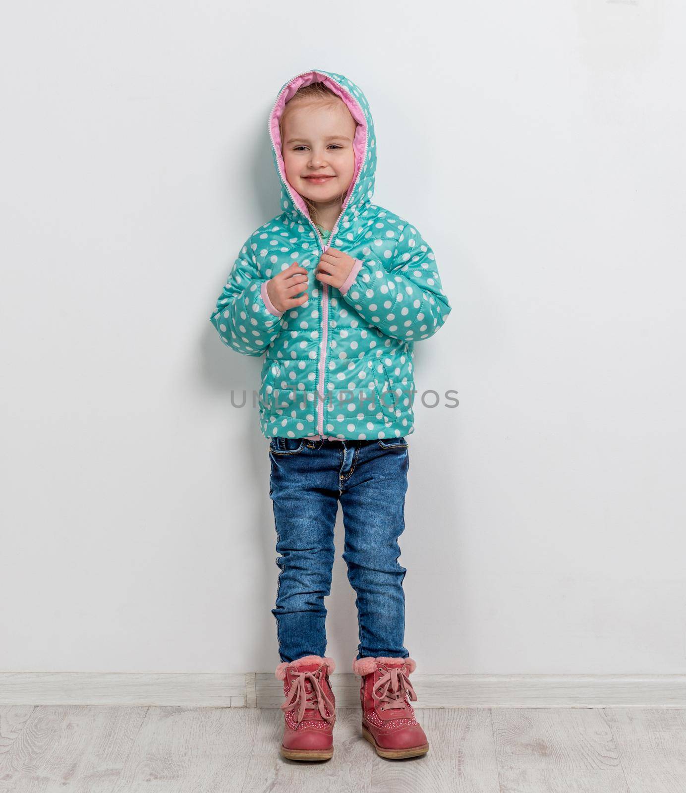 trendy lovely little girl in jeans, jacket and boots