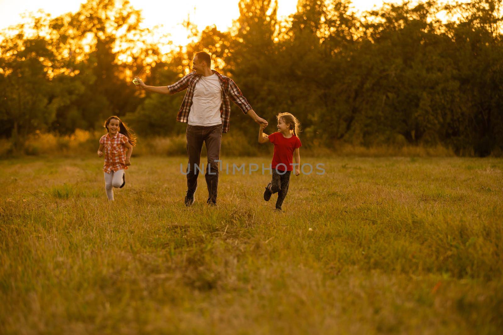 Dad with his little daughter let a kite in a field by Andelov13