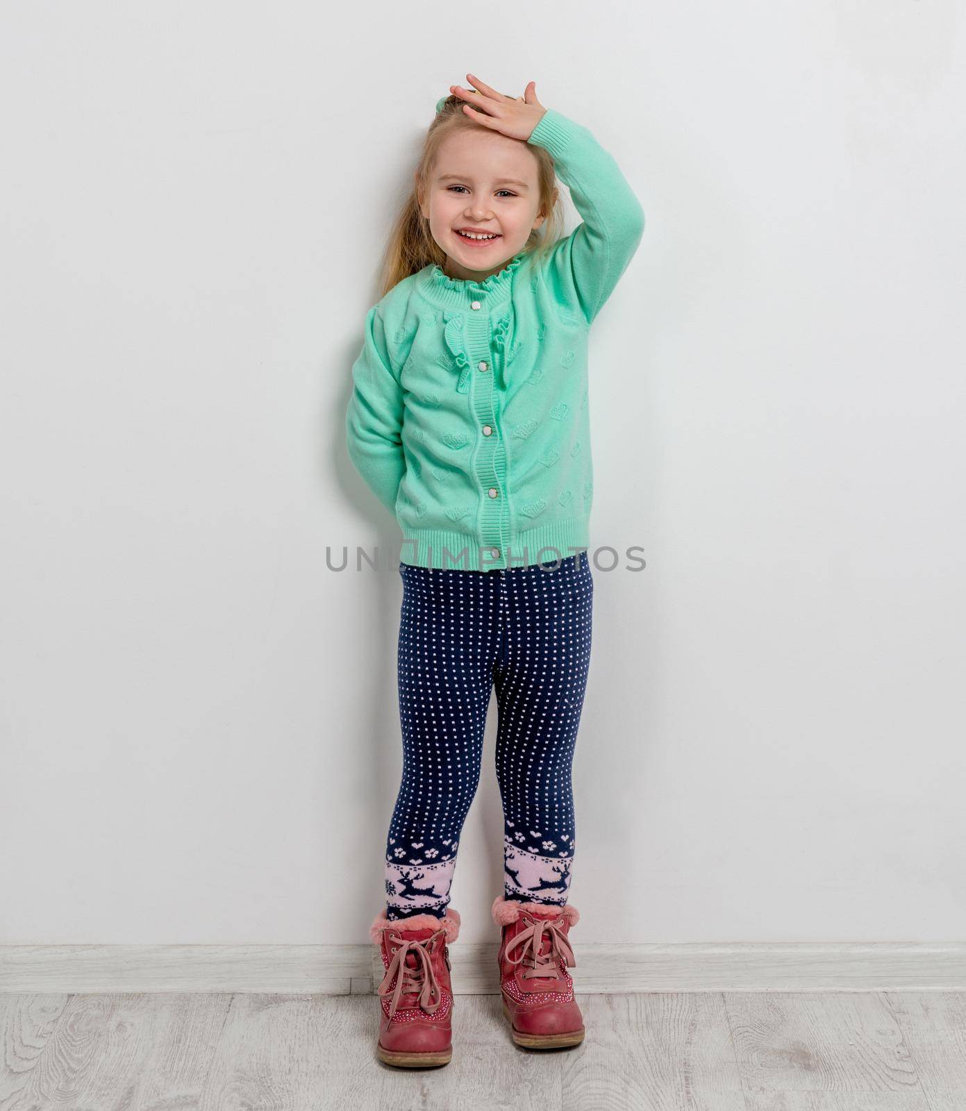 beautiful cheerful little girl with her hands in pockets of jeans