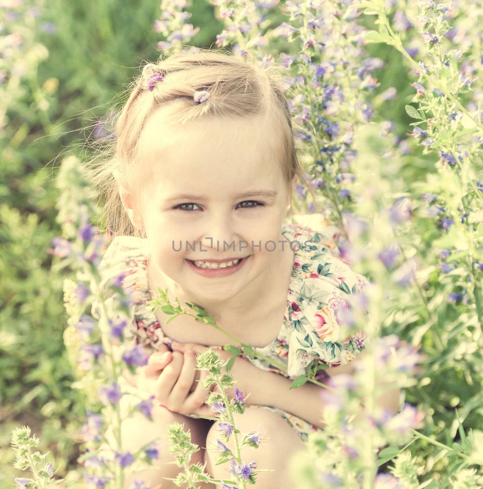 girl sitting in field full of small flowers by tan4ikk1