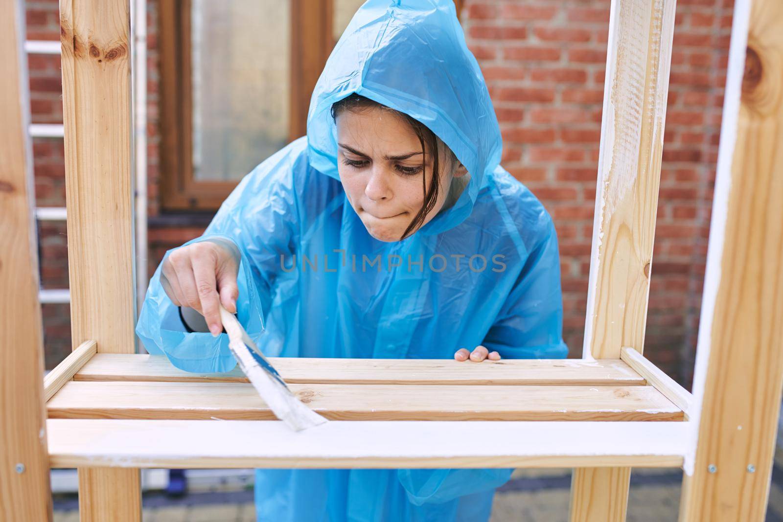 cheerful woman house painter in protective suit repairing home. High quality photo