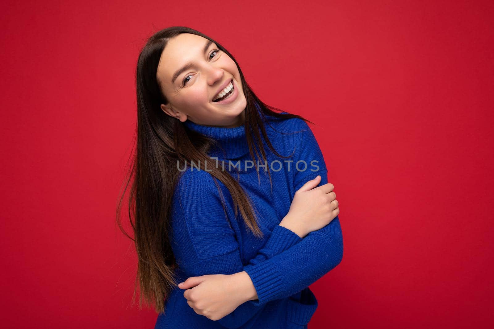 Photo shot of pretty joyful smiling young female person wearing casual trendy outfit standing isolated on colourful background with copy space looking at camera and having fun.