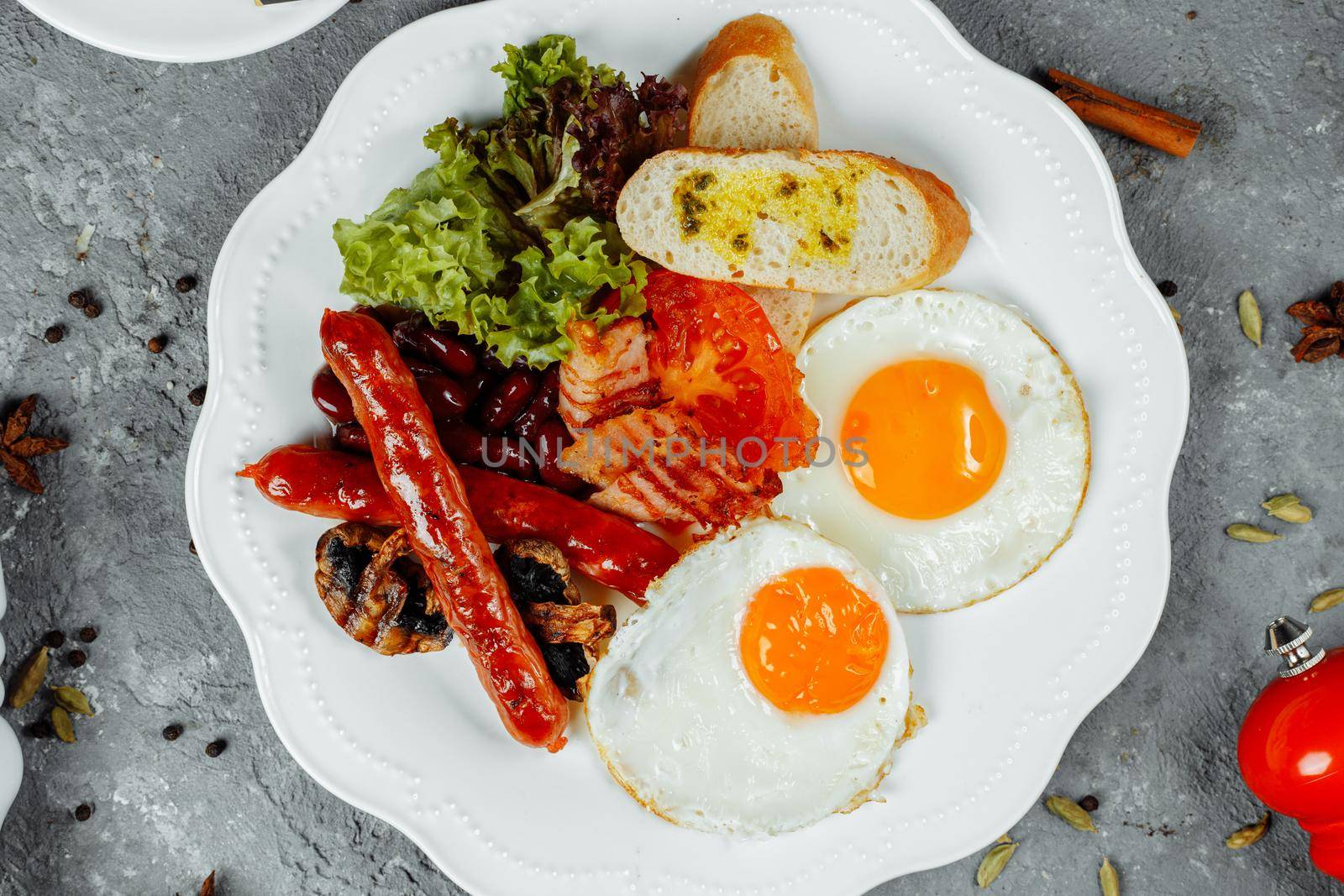 Fried breakfast with bacon, sausages and baked beans.