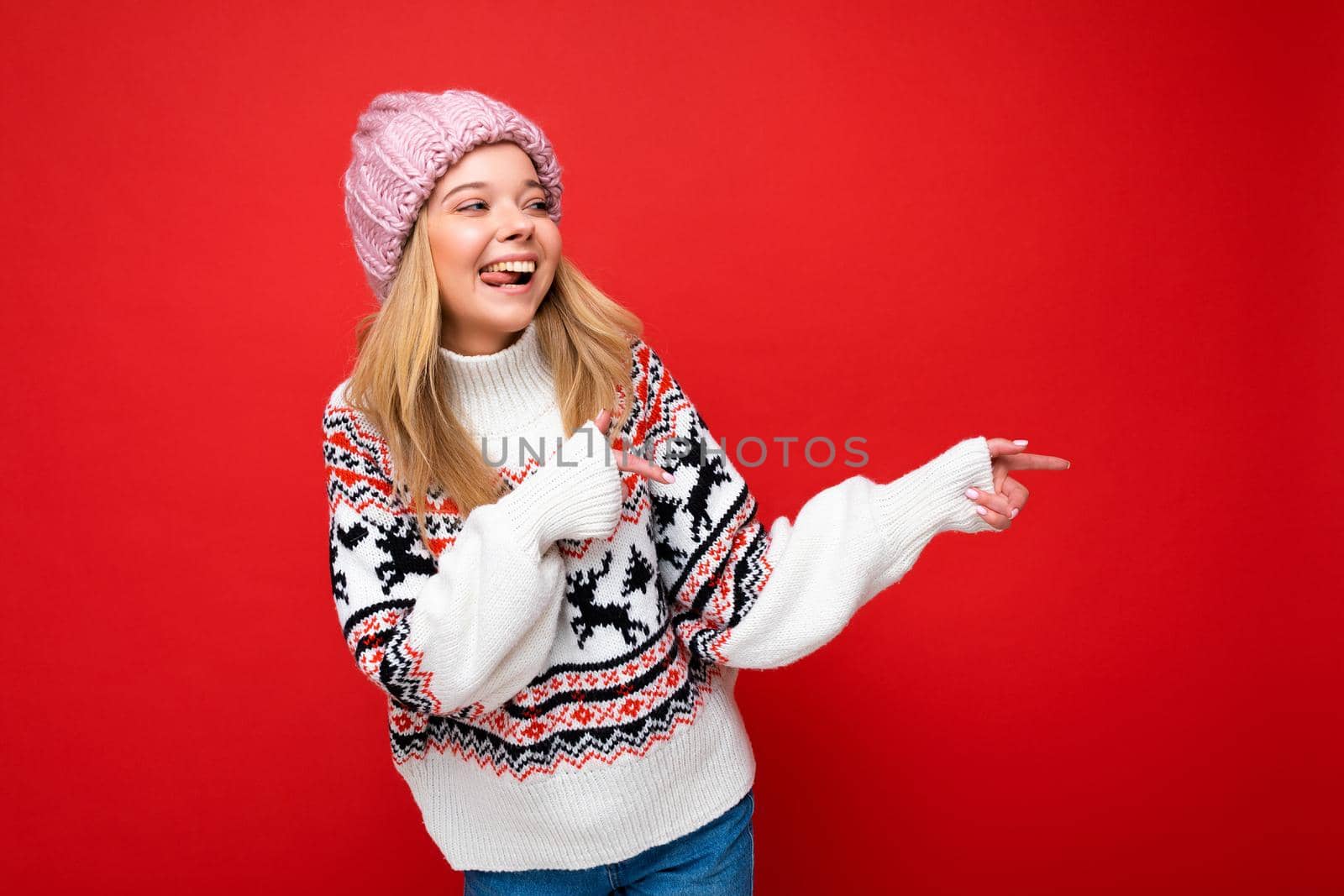 Portrait of beautiful fascinating emotional positive joyful happpy female promoter pointing to the side at copy space for advertising wearing hipster outfit isolated over background wall with empty space with sincere emotions by TRMK