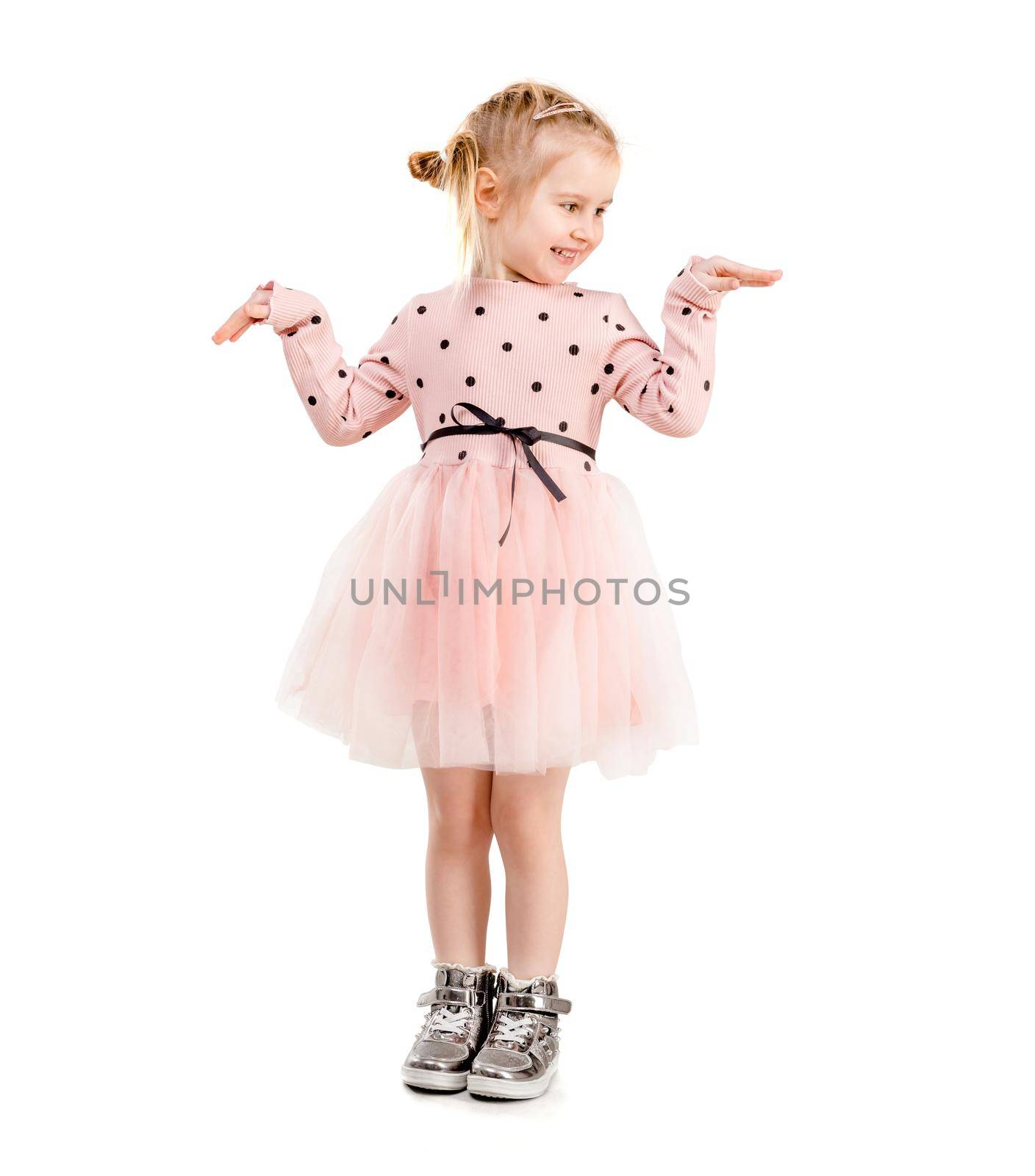 Amazing girl in a funny pose, holding her hands, dressed in pink polkadot clothes, isolated