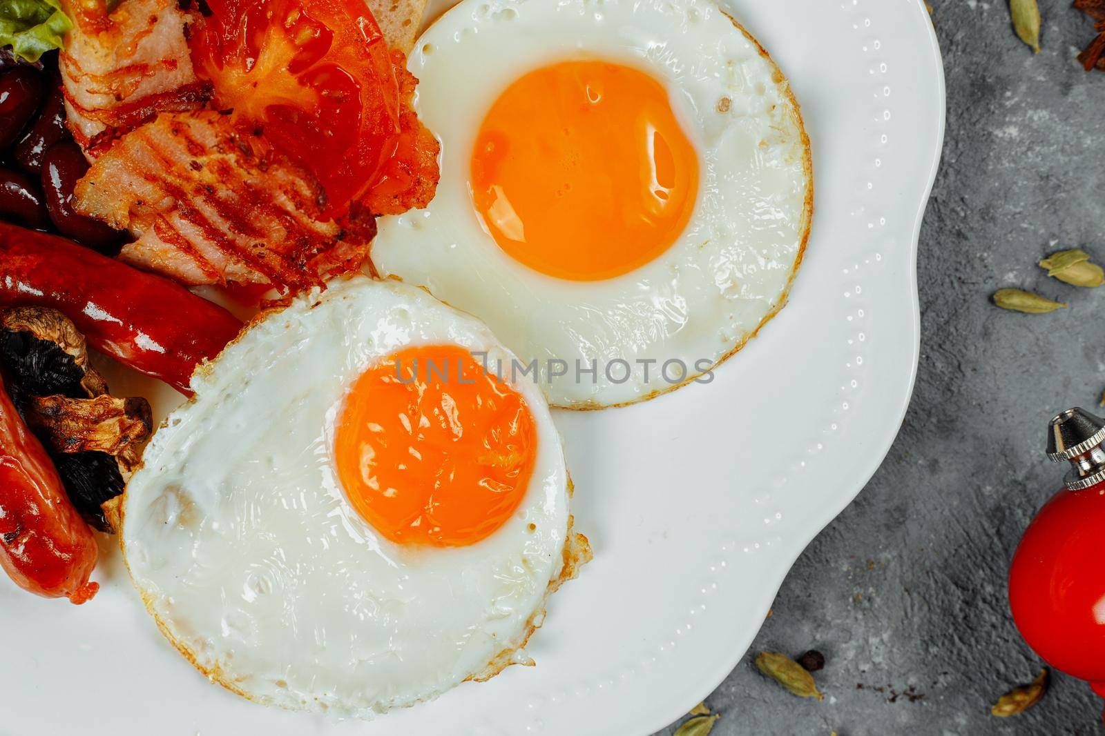 Fried breakfast with bacon, sausages and baked beans.