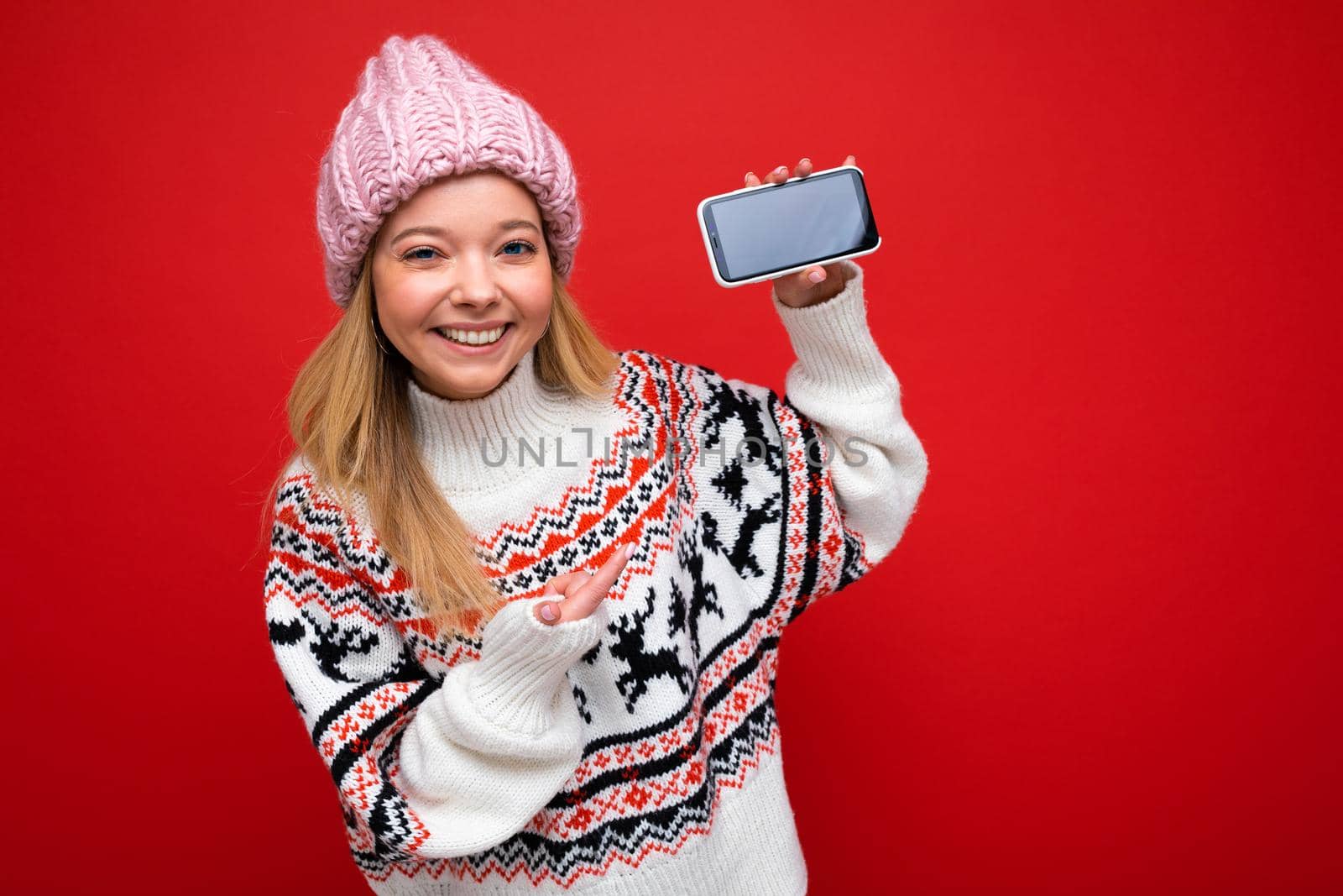 Image of a shocked young beautiful woman posing isolated over red wall background play games by mobile phone.