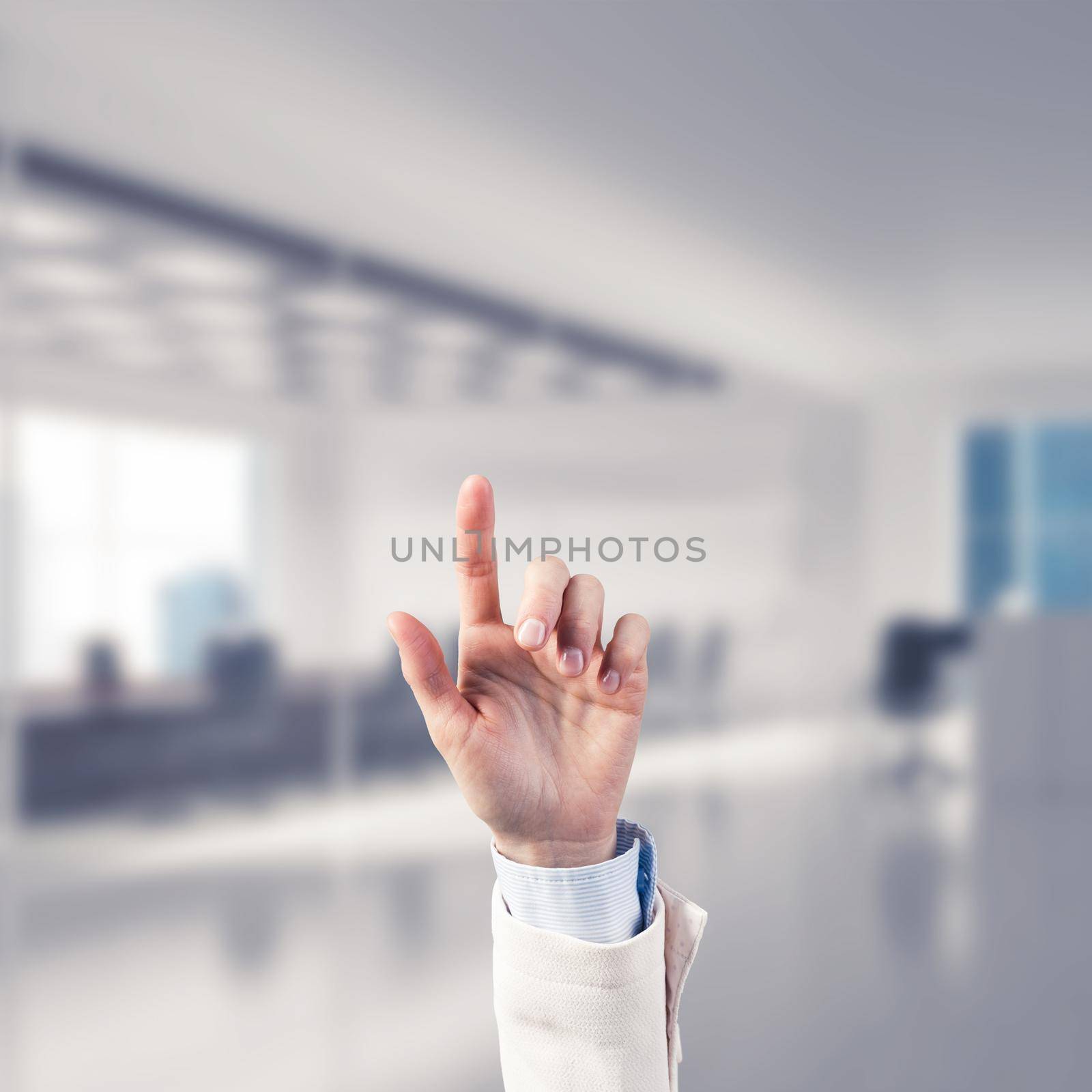 Close of businesswoman hand touching screen with finger and office at background