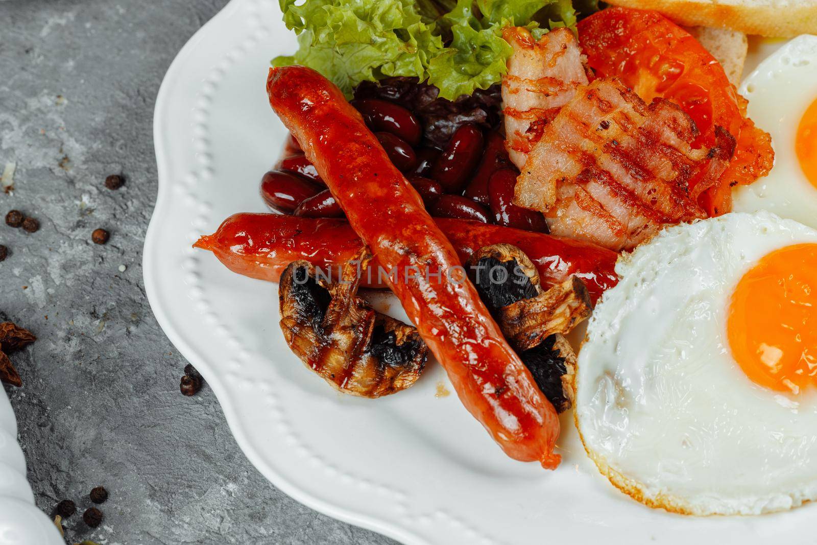 Fried breakfast with bacon, sausages and baked beans by UcheaD