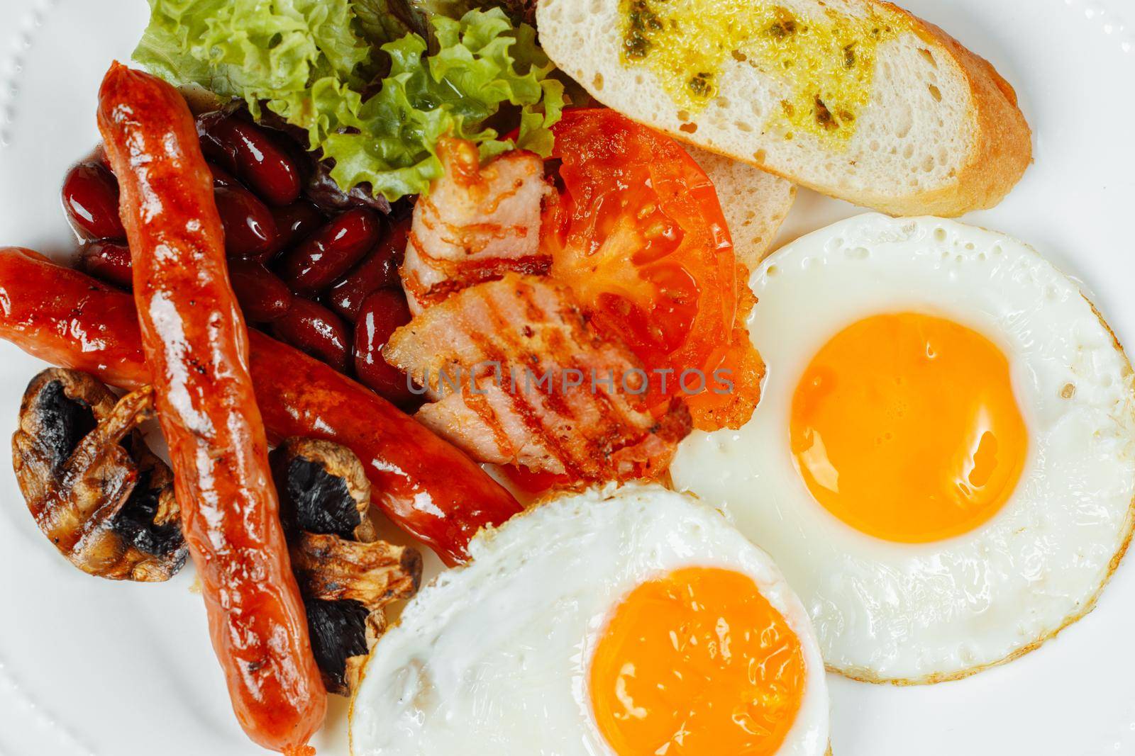 Fried breakfast with bacon, sausages and baked beans.