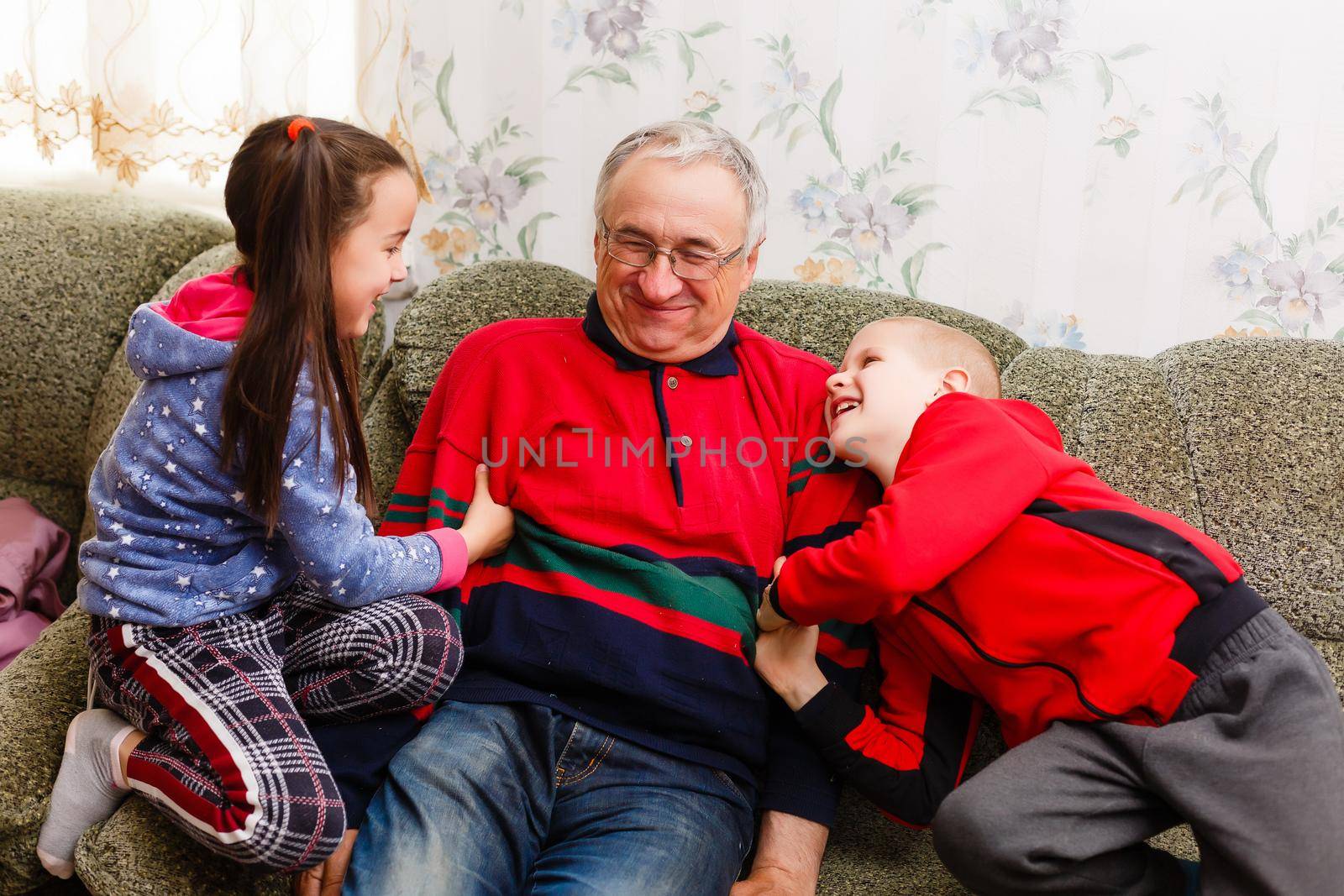 grandfather spends time with grandchildren in the living room by Andelov13