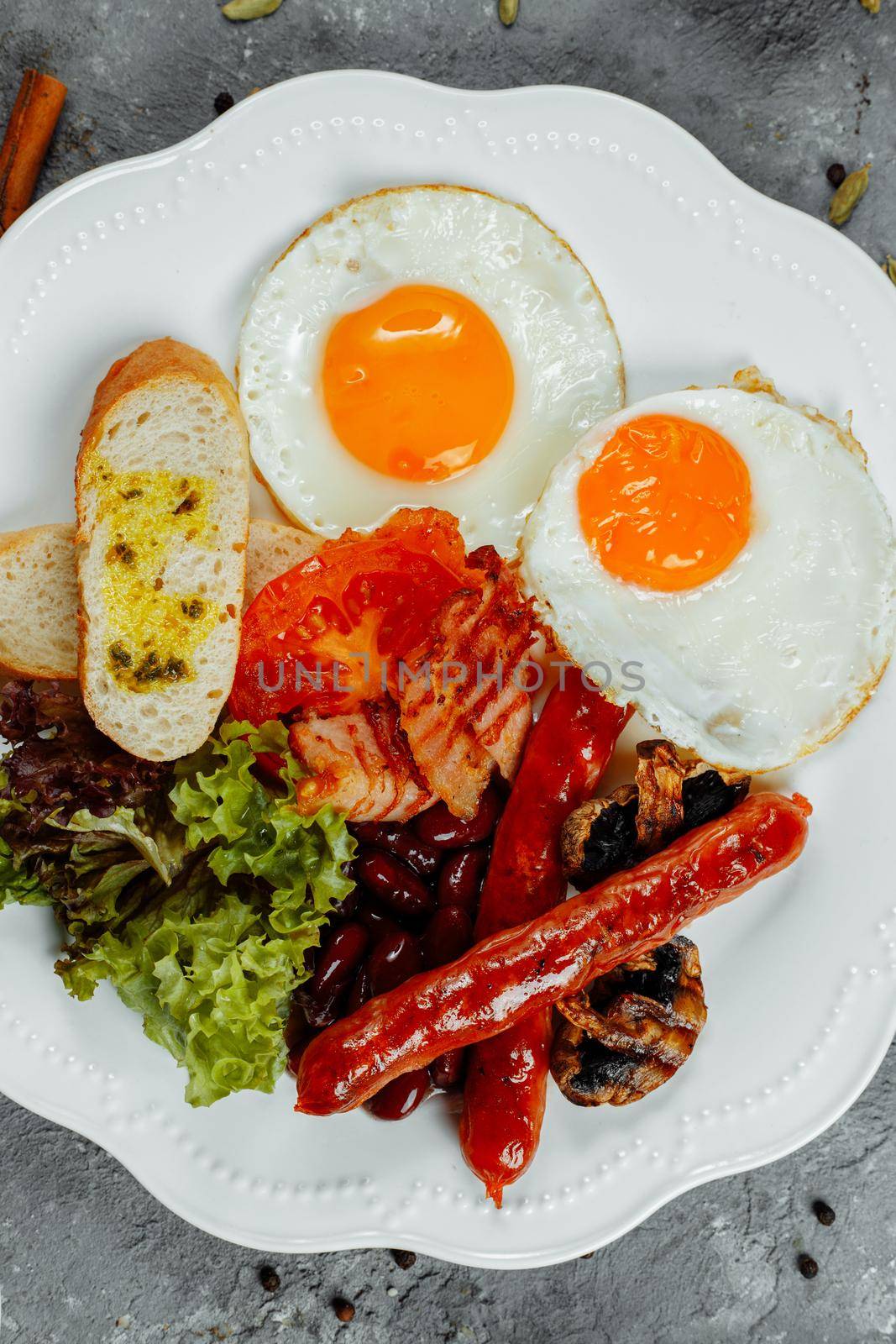 Fried breakfast with bacon, sausages and baked beans.