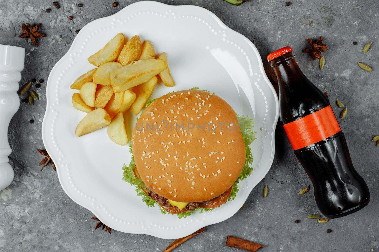 hamburger with fries and salad on the plate.