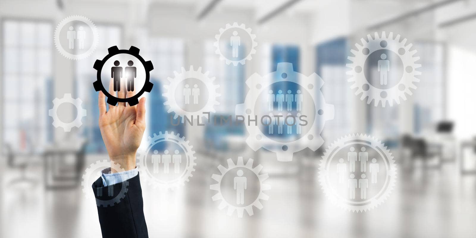 Close of businesswoman hand touching gears on screen with finger and office at background