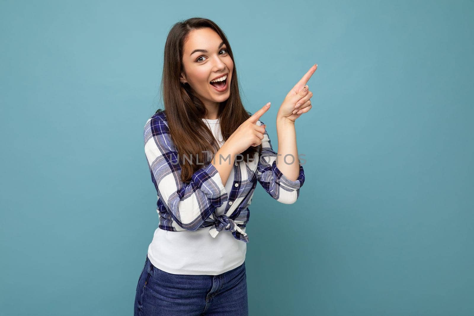 Close up photo of pretty astonished young woman pointing fingers up at copyspace presenting incredible ads promo with impressed scream wow omg emotions wearing good look outfit isolated over background with free space.
