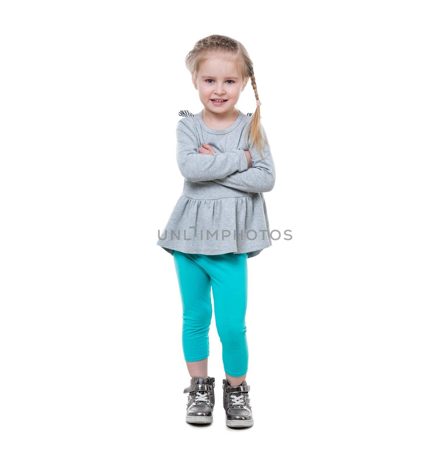 Sweet little girl with nice hairstyle standing with her arms crossed, smiling widely, isolated