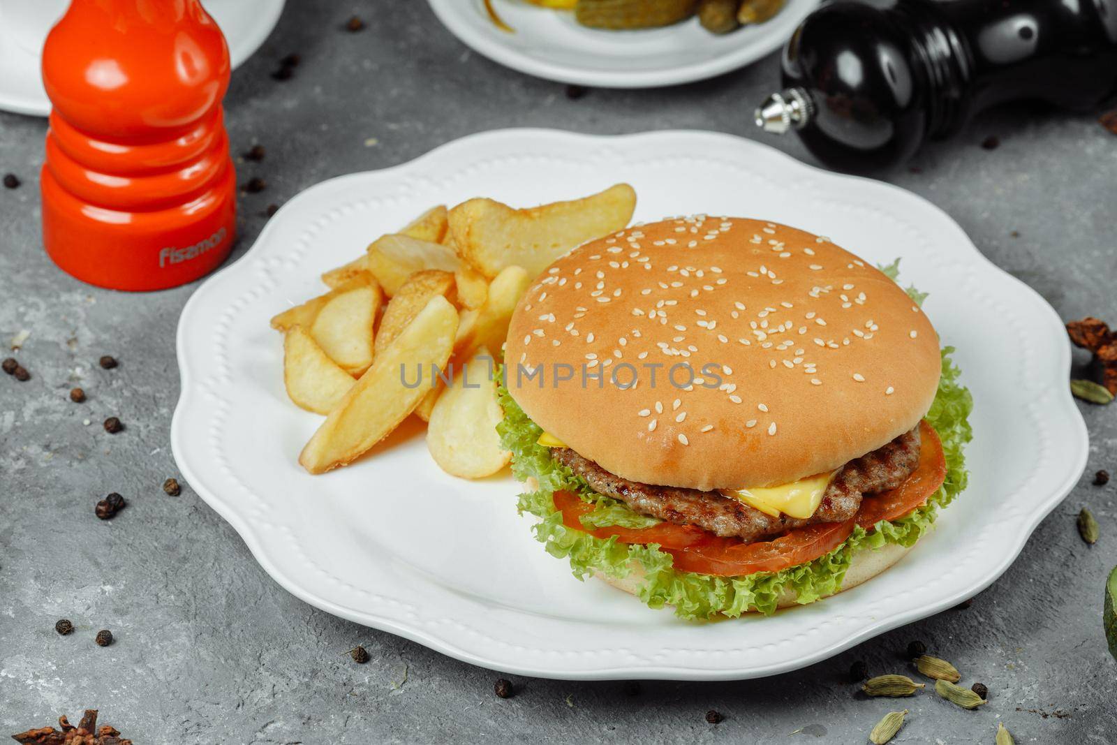 hamburger with fries and salad on the plate.