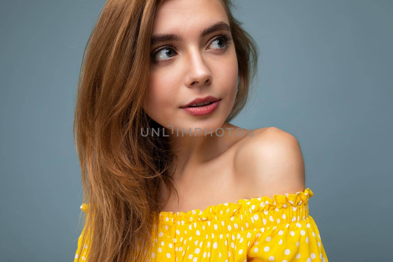 Closeup photo of young attractive dark blonde woman with sincere emotions isolated on background wall with copy space wearing stylish summer yellow dress. Cute concept.