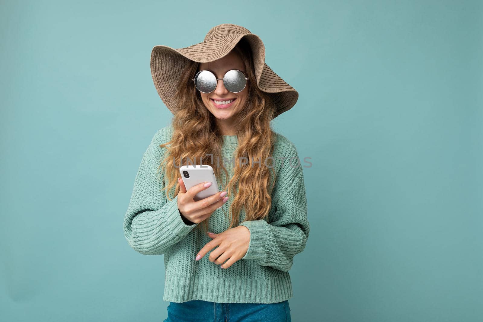 young woman over isolated blue background thinking and sending a message.